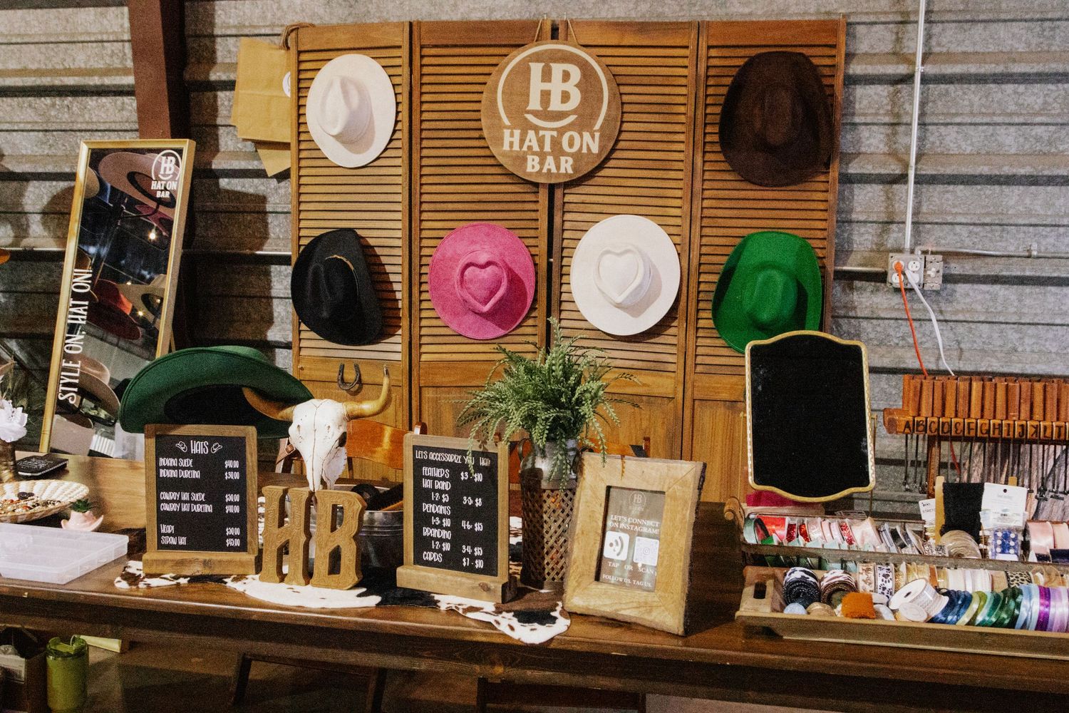 Retail wall display with hats and merchandise on slatted wood paneling.