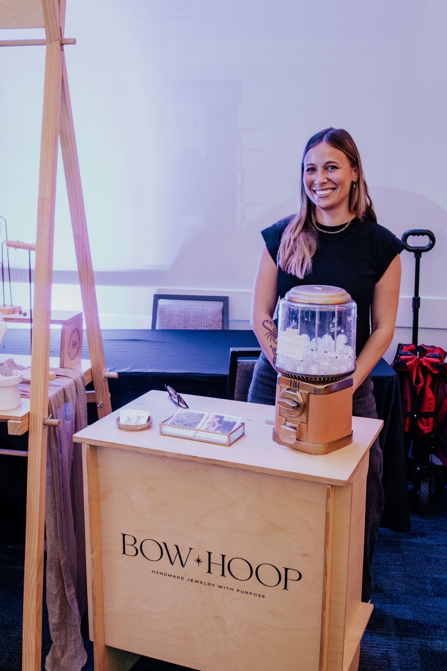 A wooden retail display booth with Bow+Hoop branding.