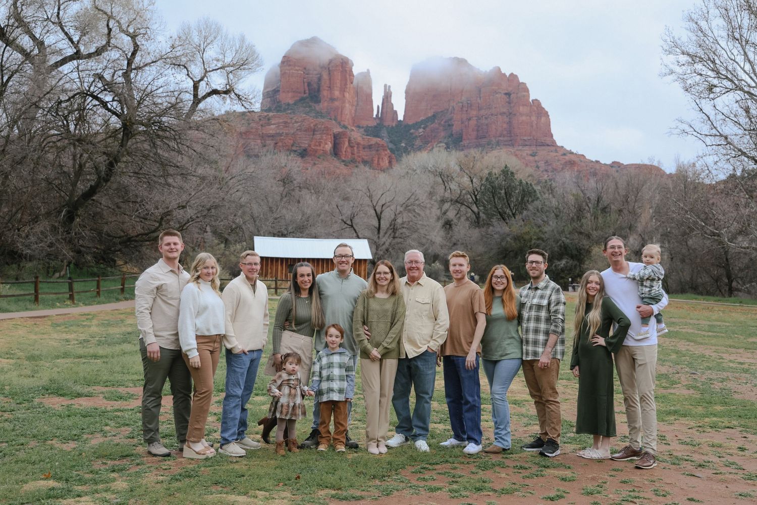 Family group portrait with red rock formations of Sedona visible in the background.
