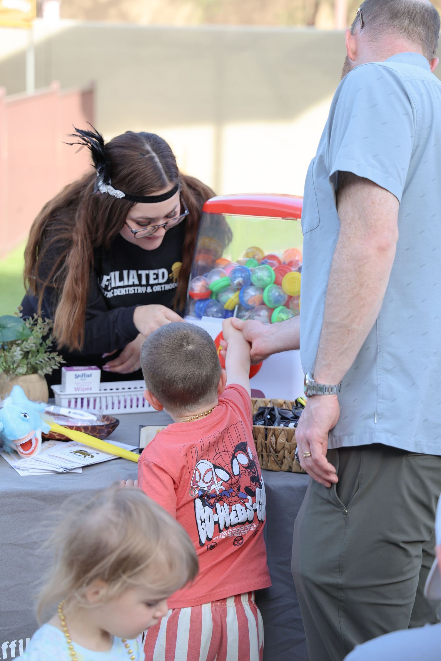 People gathering around an outdoor food sampling event with colorful displays and serving stations.