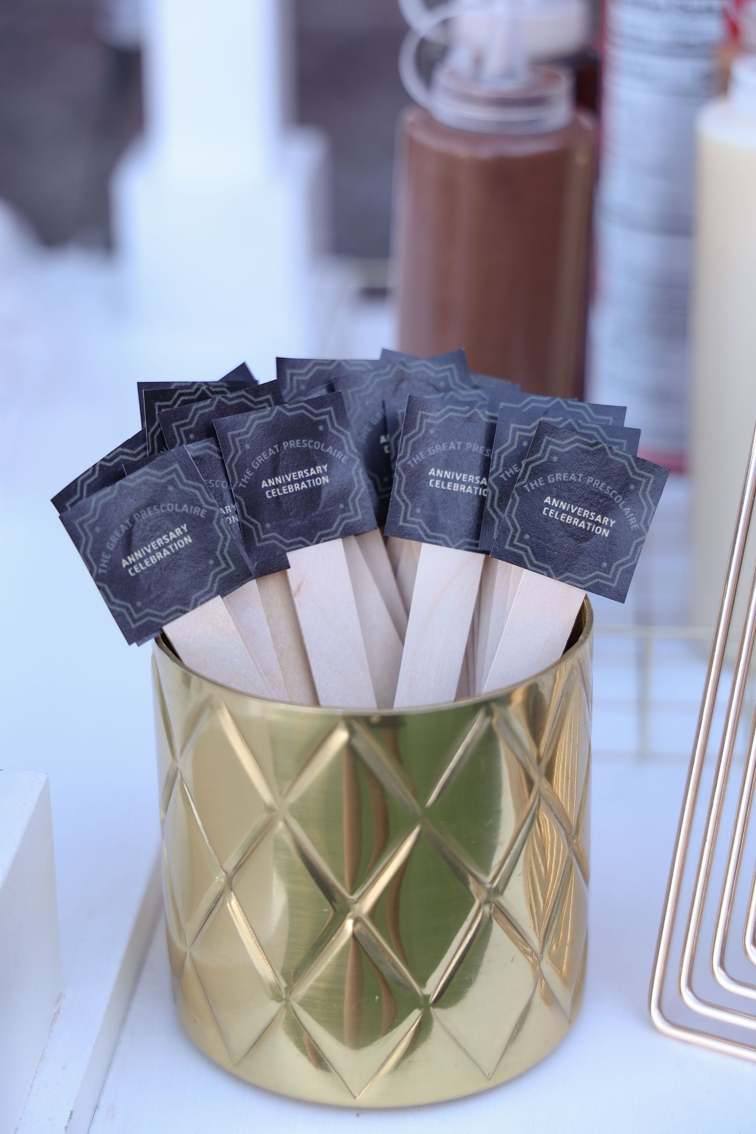 Black tea bags arranged in a gold metallic container with geometric patterns.