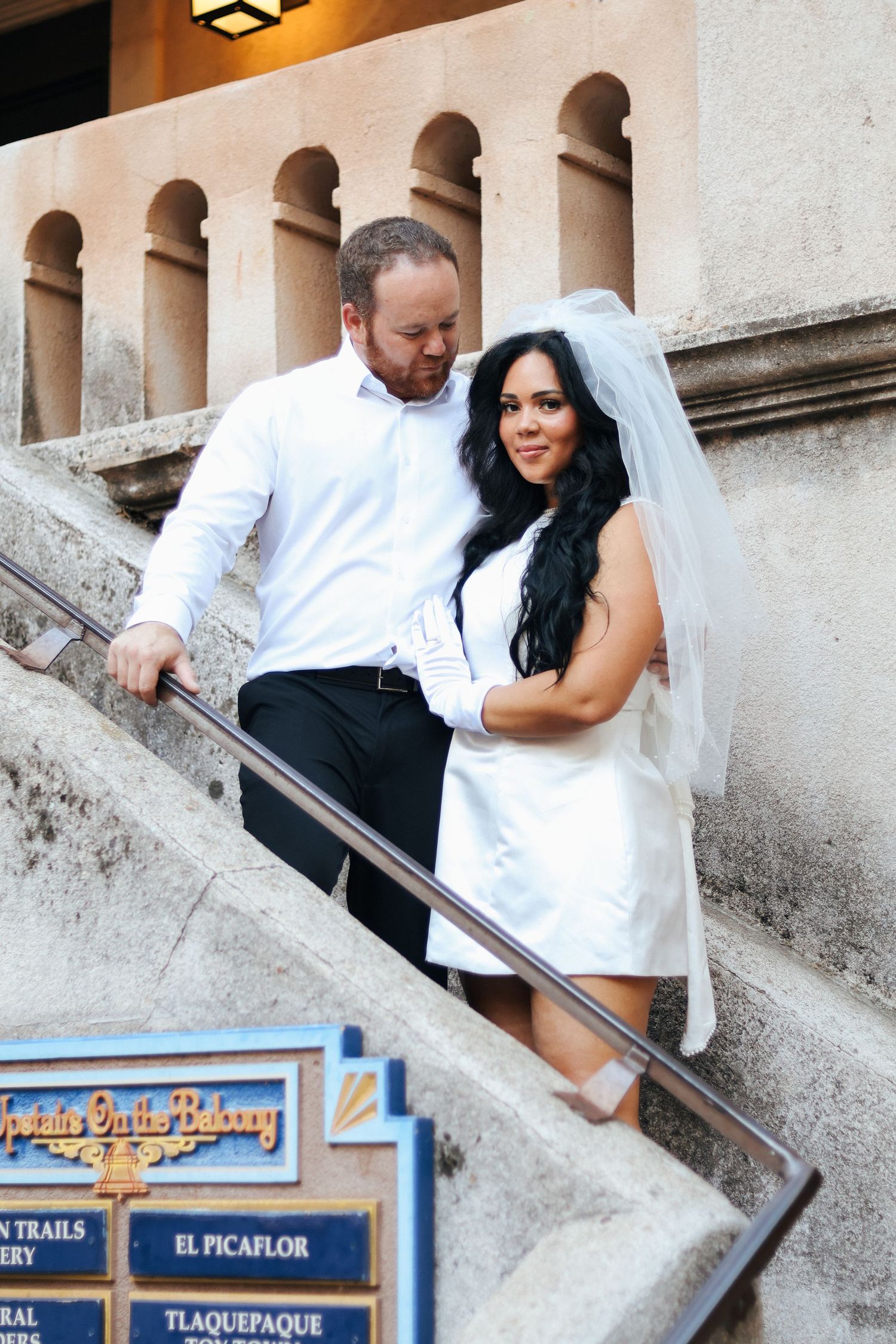 Bride and groom create fun poses on architectural steps during their photo session.