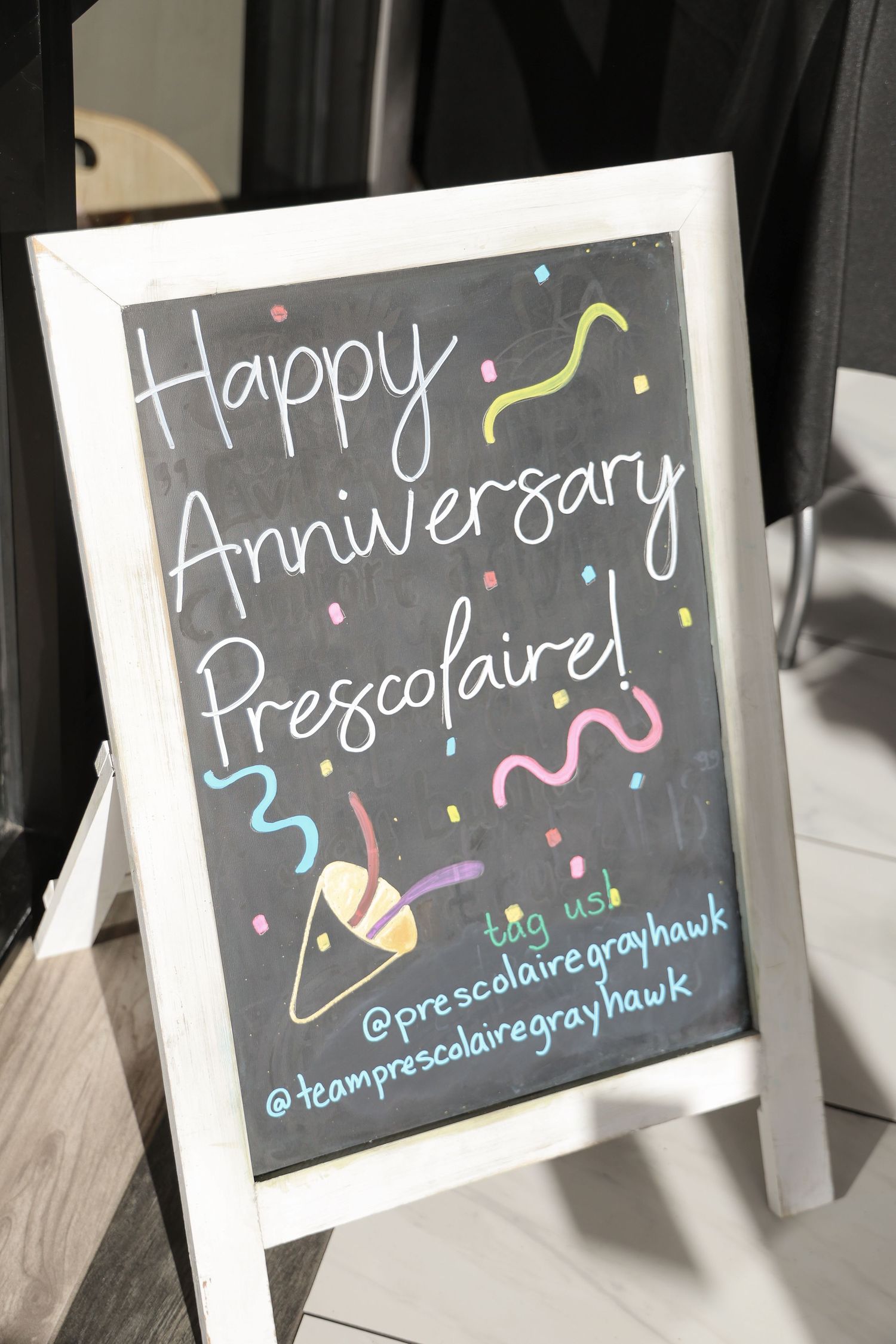 Handwritten chalkboard signs displaying 'Happy Anniversary' messages with colorful decorative elements.