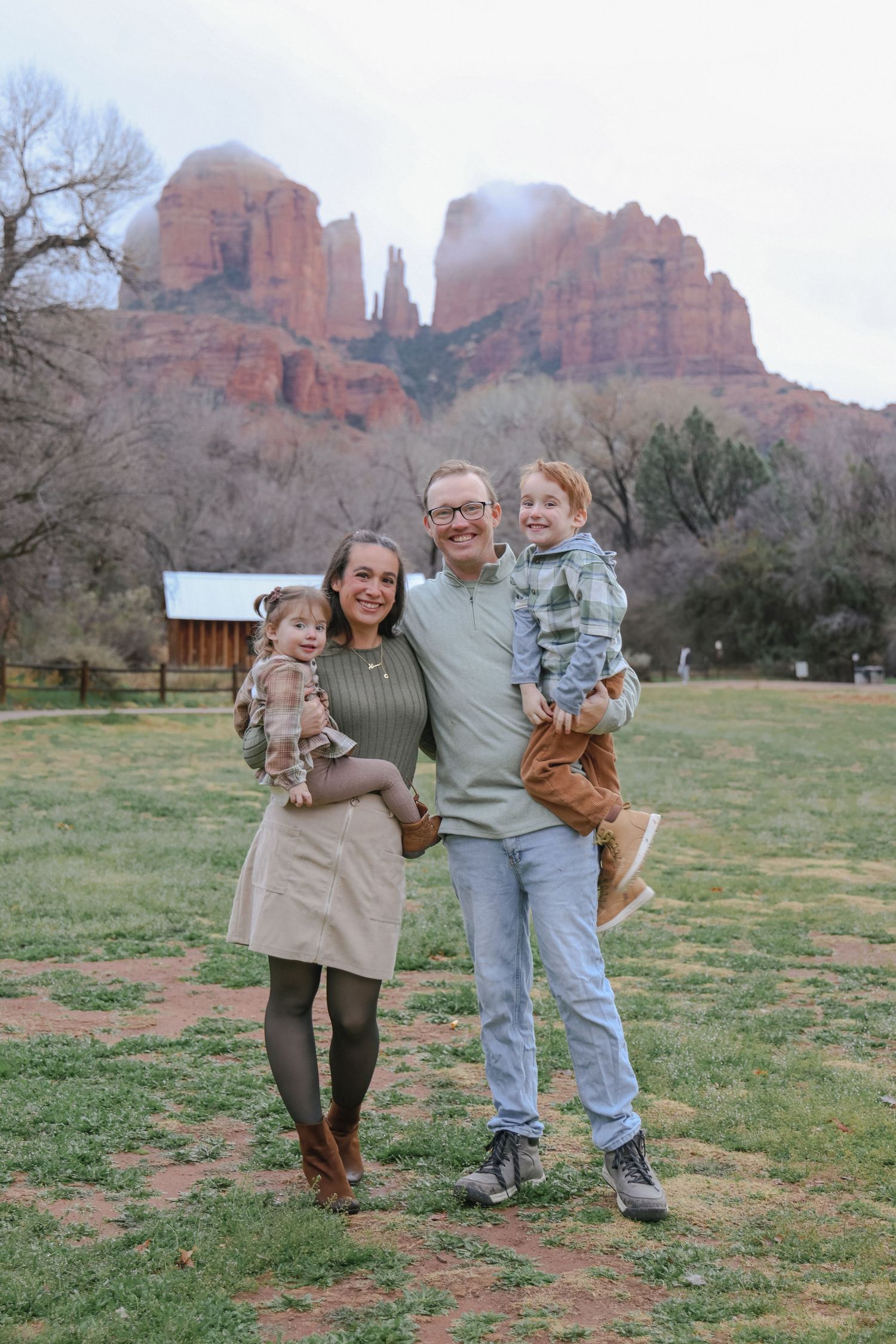 Family portrait with red rock formations of Sedona's Cathedral Rock in background.