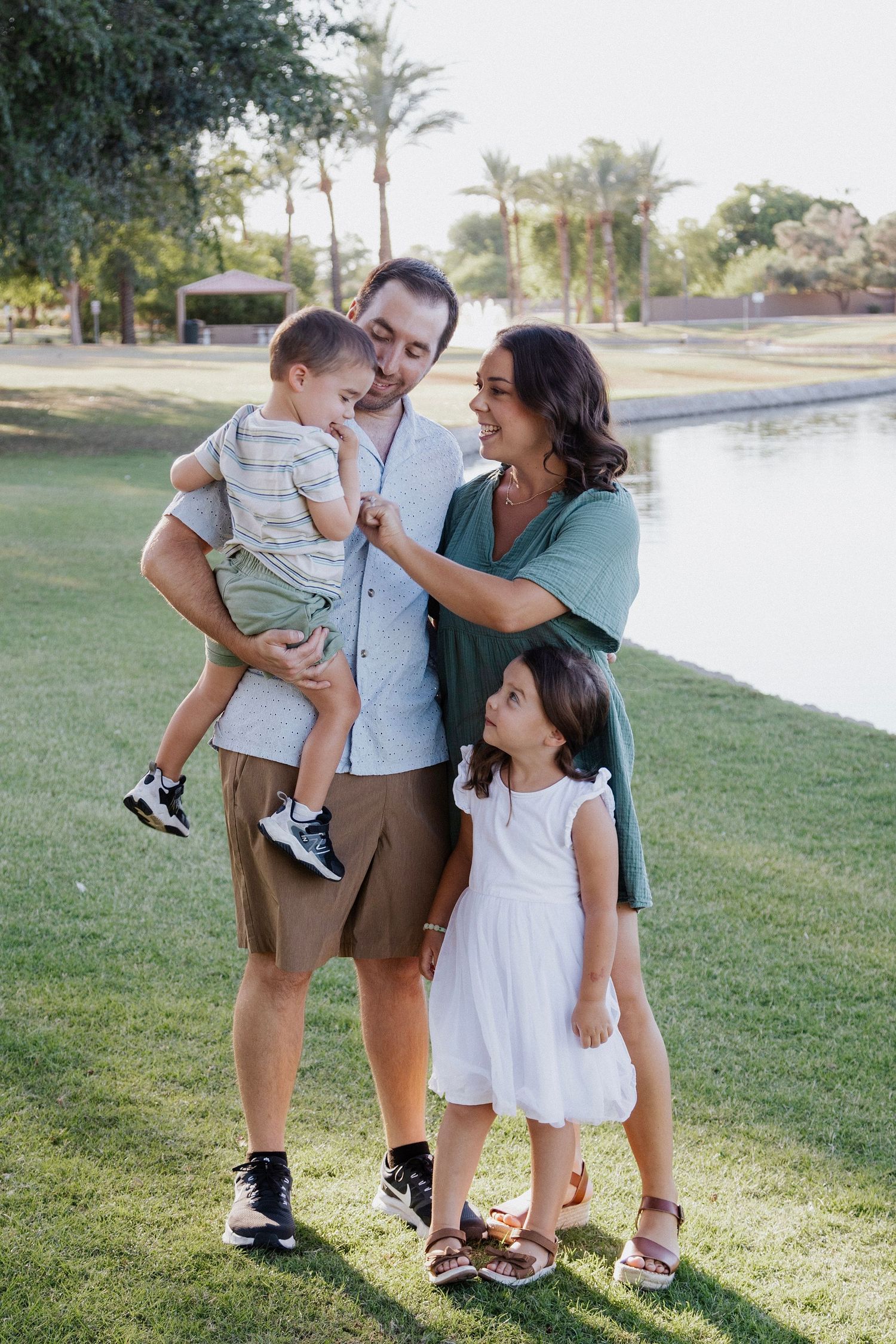 Candid family portrait showing joyful interactions between parents and children by the water.