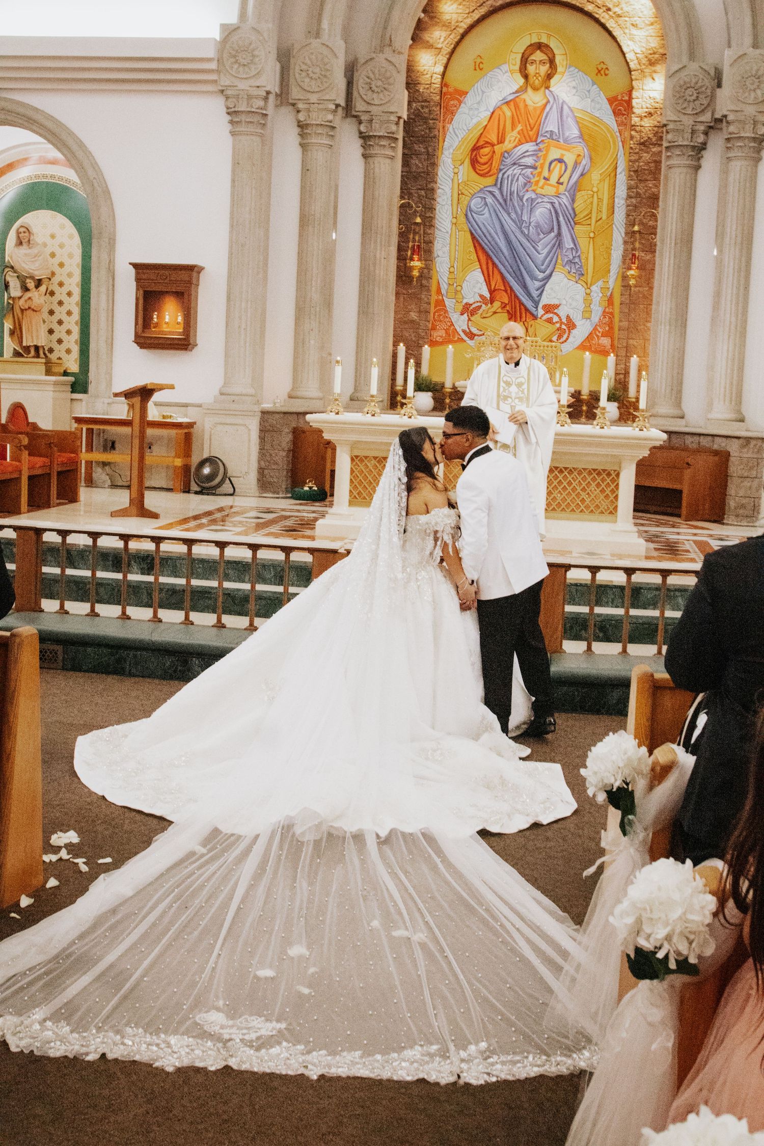 Dramatic wedding dress with cathedral train displayed in ornate church interior.