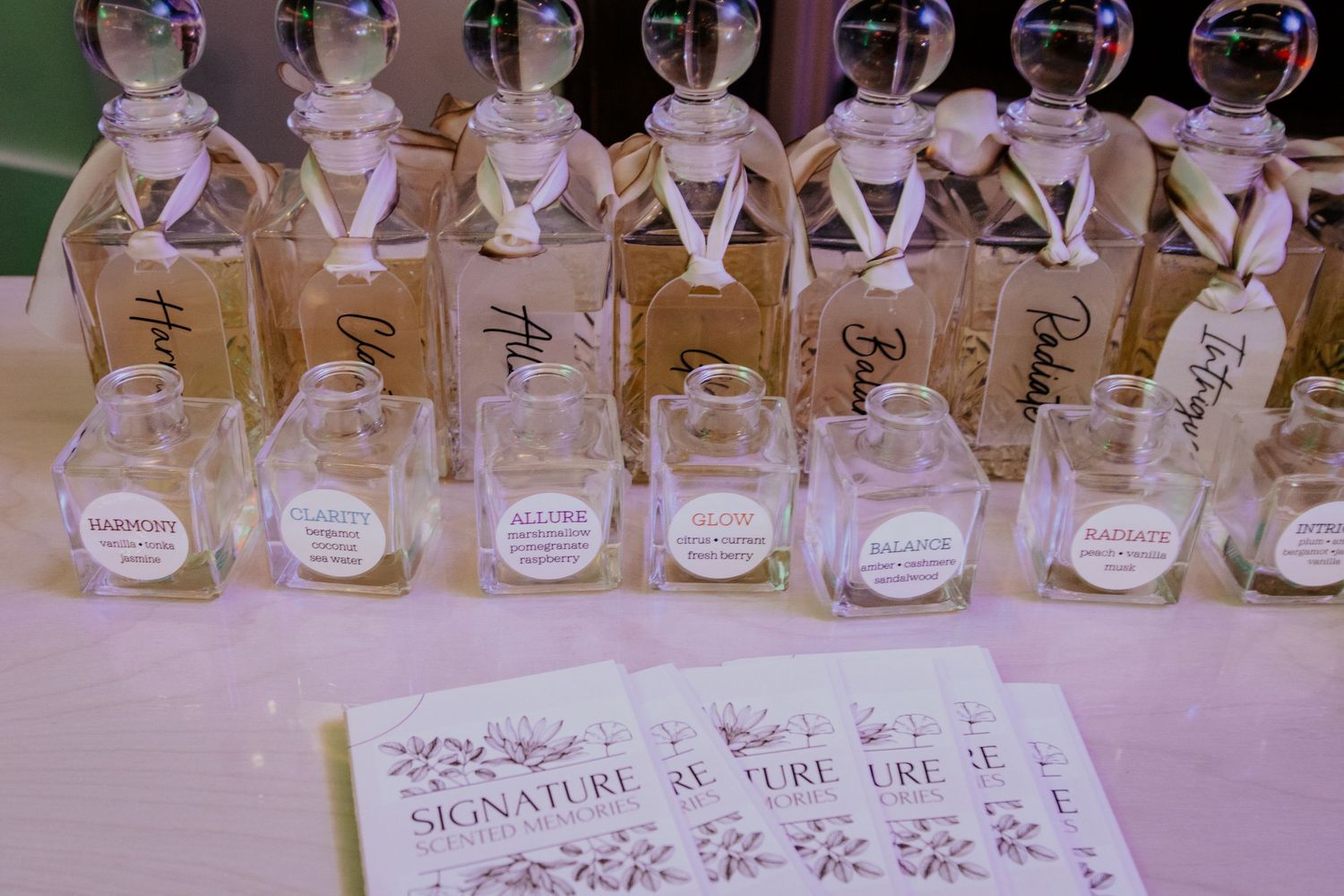 Glass bottles of perfume arranged in neat rows on a wooden display shelf.