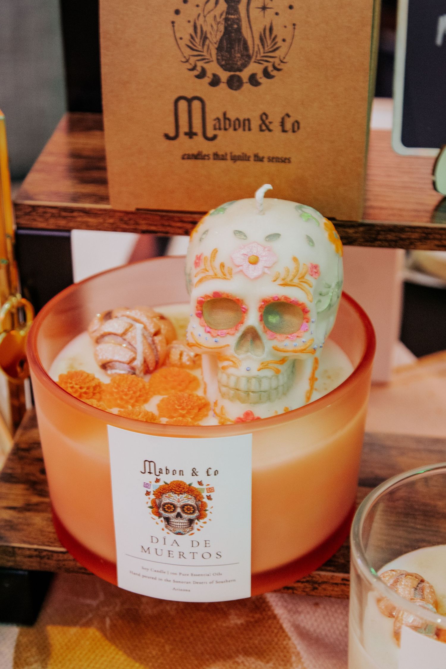 Decorative sugar skulls displayed in orange bowls with branded packaging.
