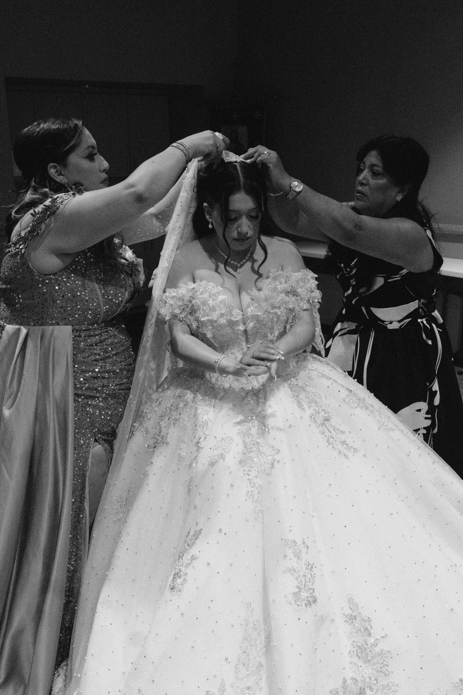 Wedding dress preparation scene with dramatic black and white lighting.