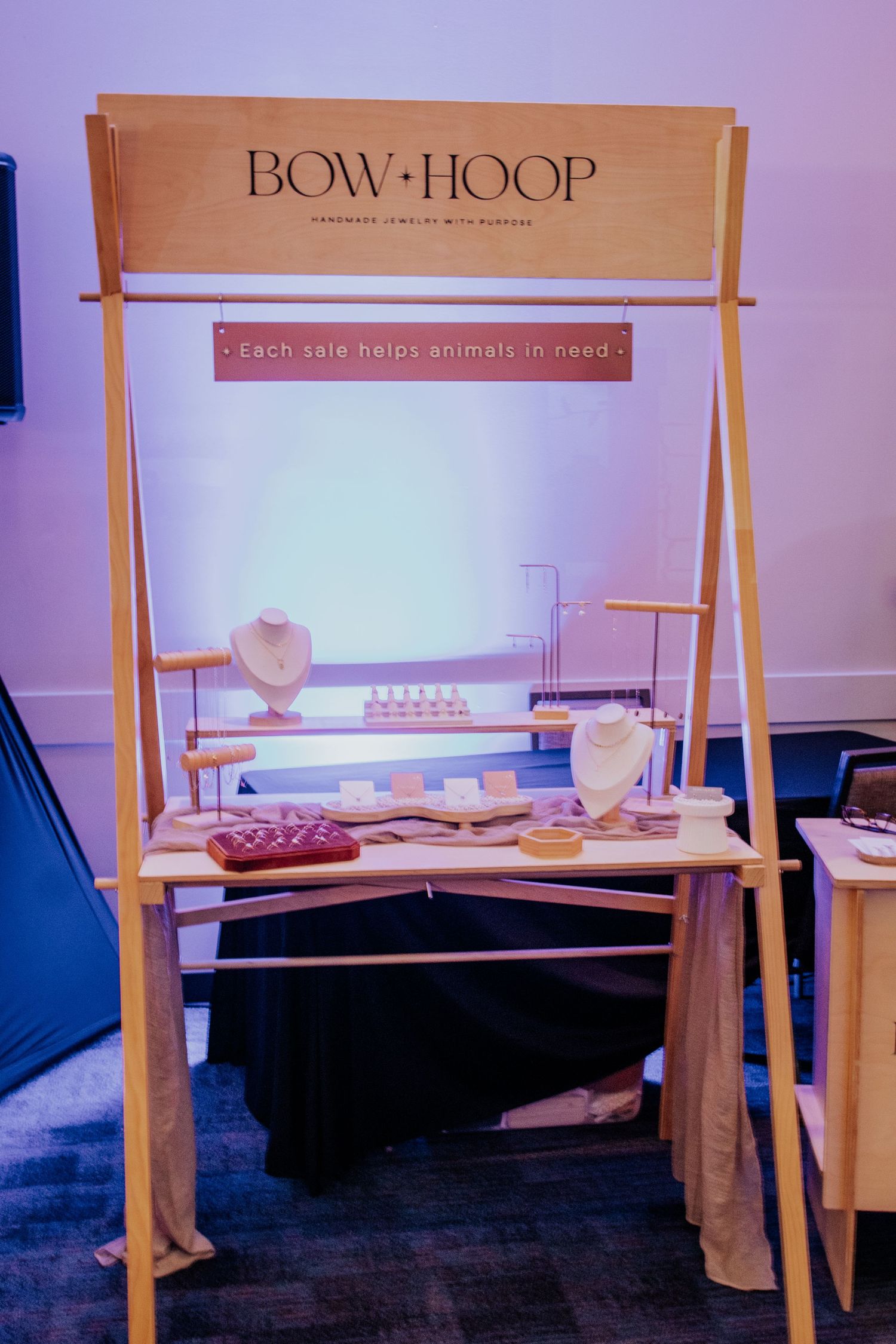A wooden A-frame display stand with jewelry and accessories.