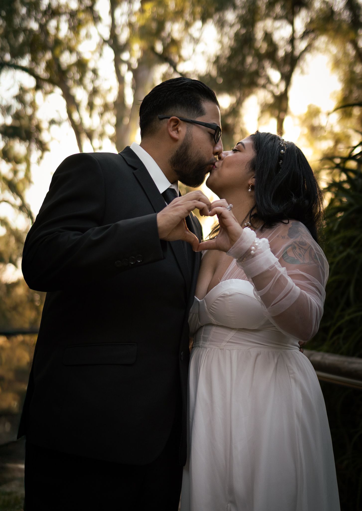 A romantic wedding couple shares tender kisses in a garden setting during golden hour in a series of intimate portraits.