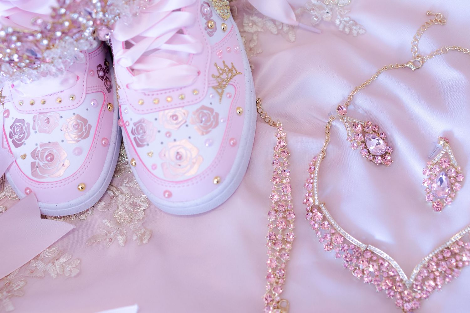 Soft pink baby shoes and accessories with glittery details on light background. At a Quinceañera