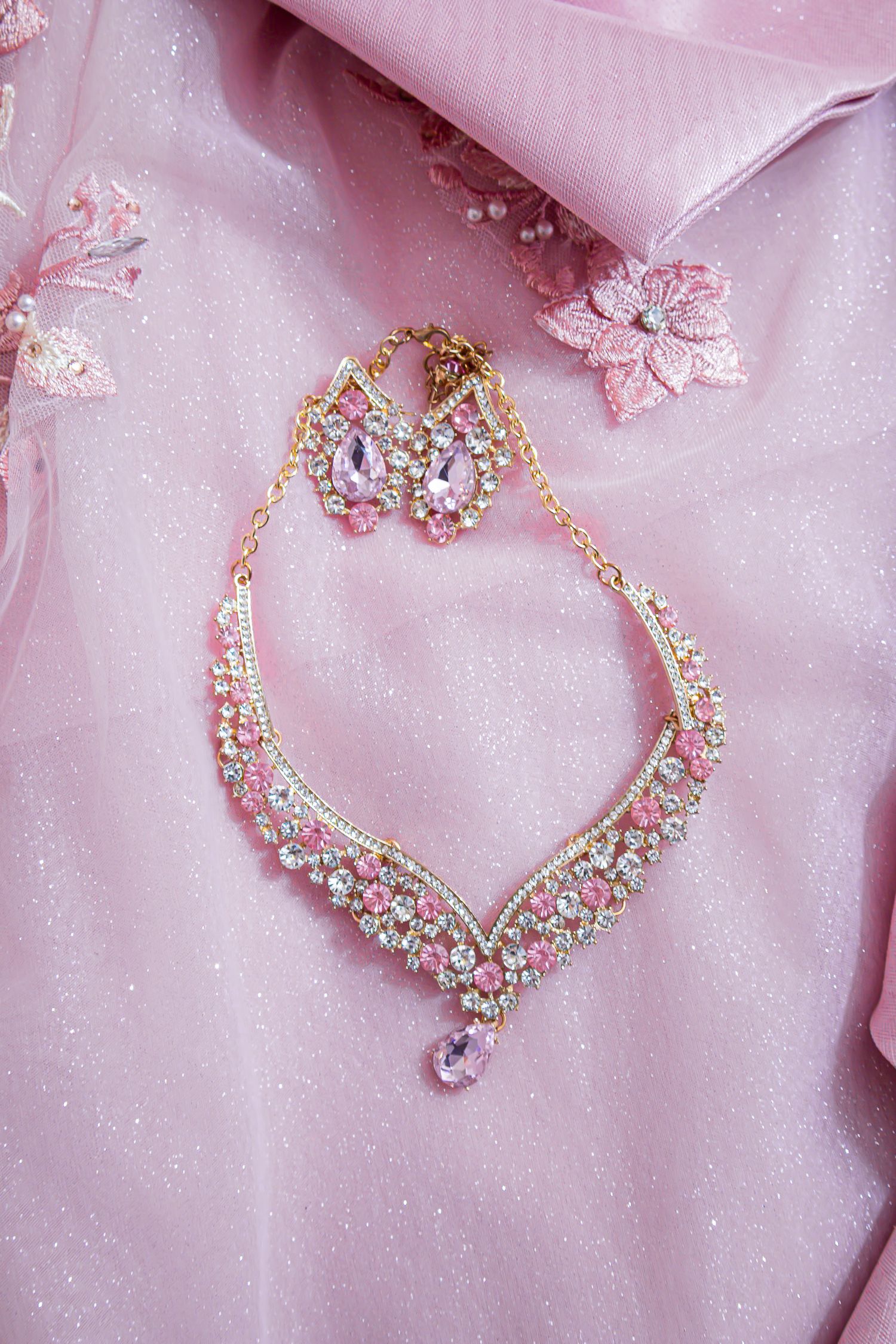Delicate pink embroidered fabric with crystal embellished jewelry details. At a Quinceañera