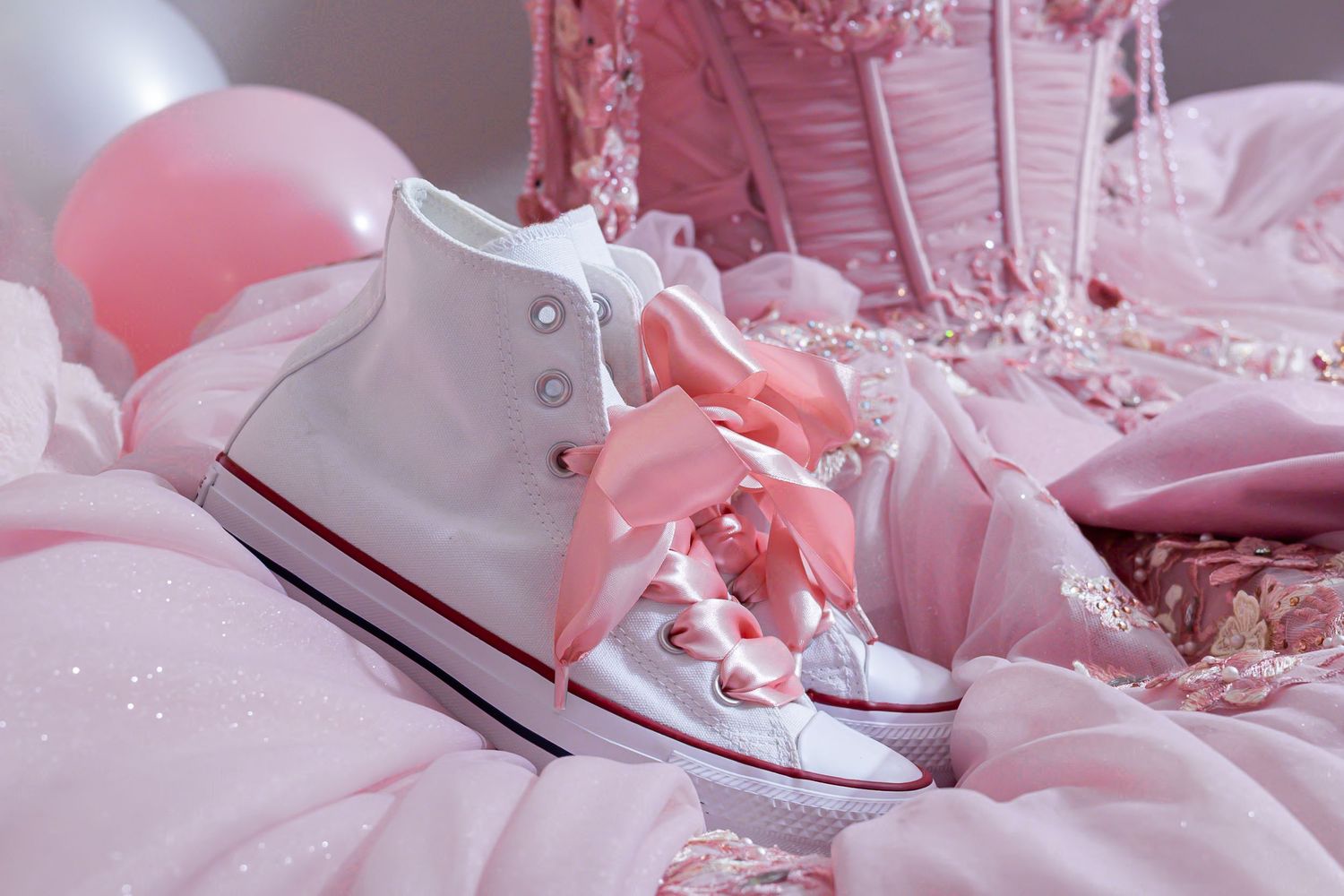 Pink satin fabric with white sneakers and delicate lace details. At a Quinceañera