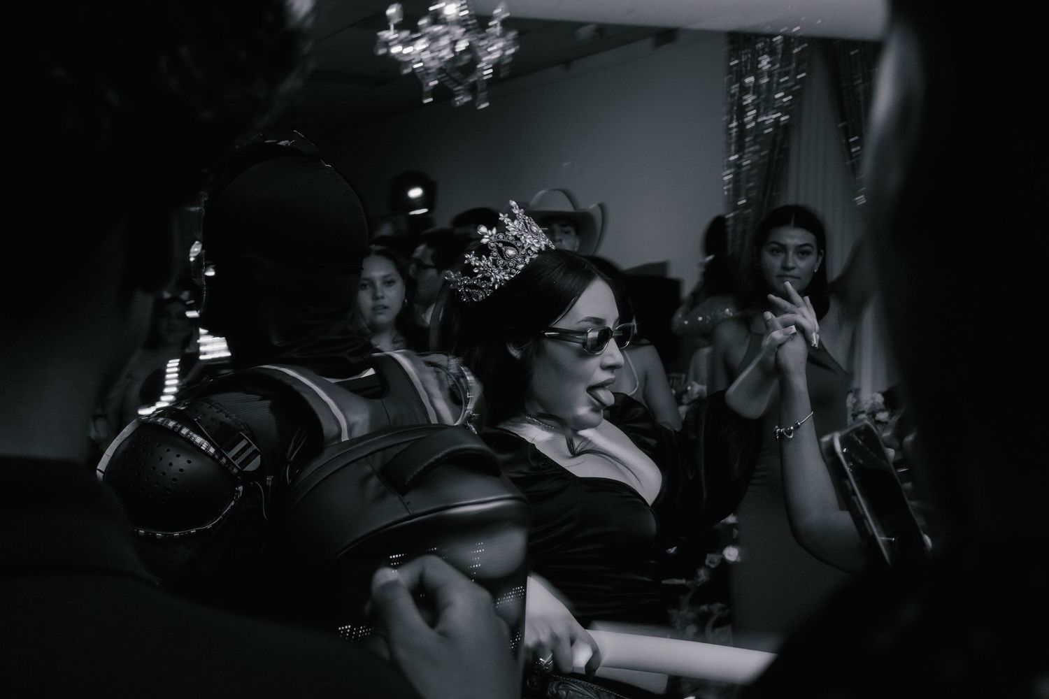 Black and white photo showing a crowd of people dancing and celebrating at a lively party.