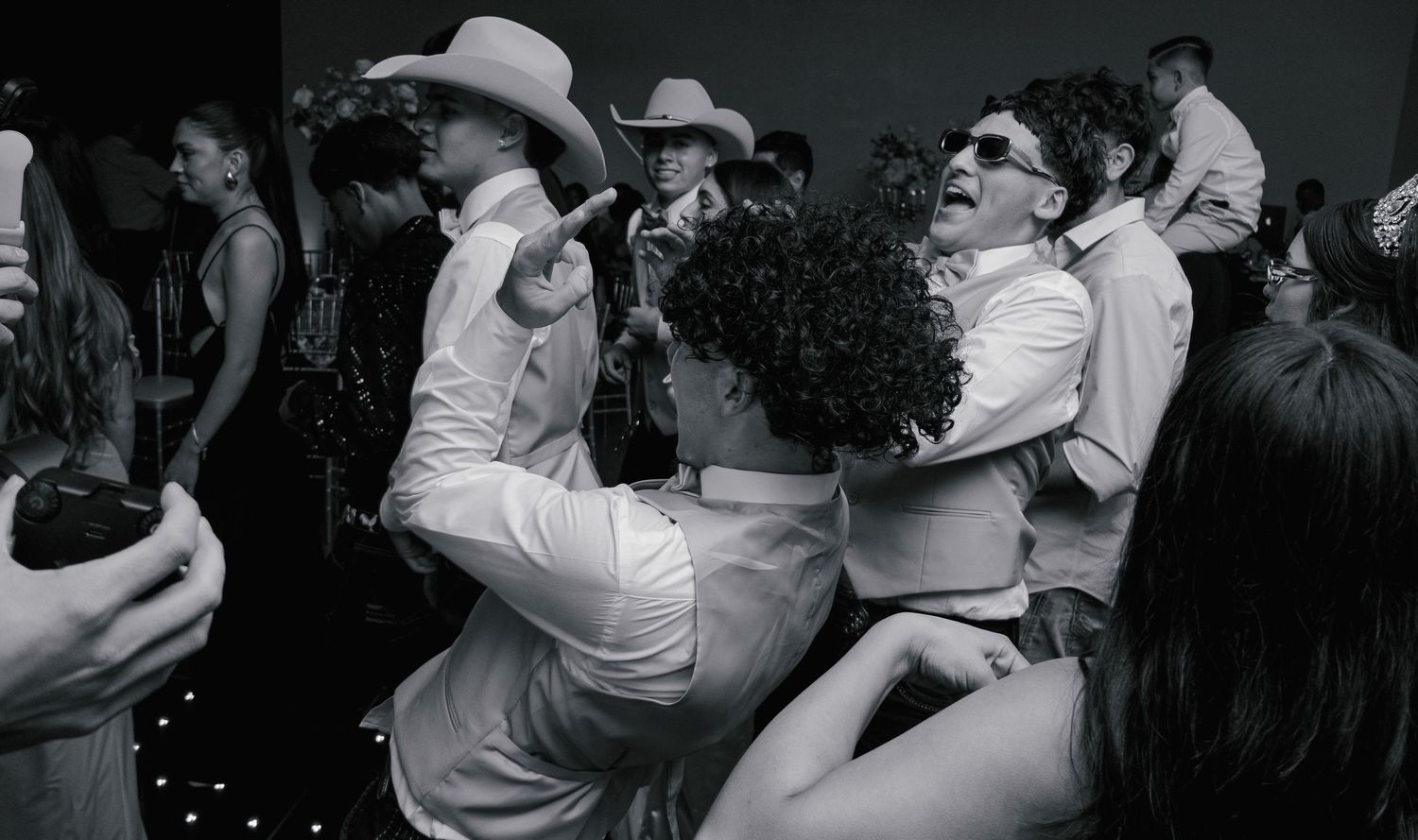 Black and white photo of people dancing and embracing at what appears to be a party or celebration.