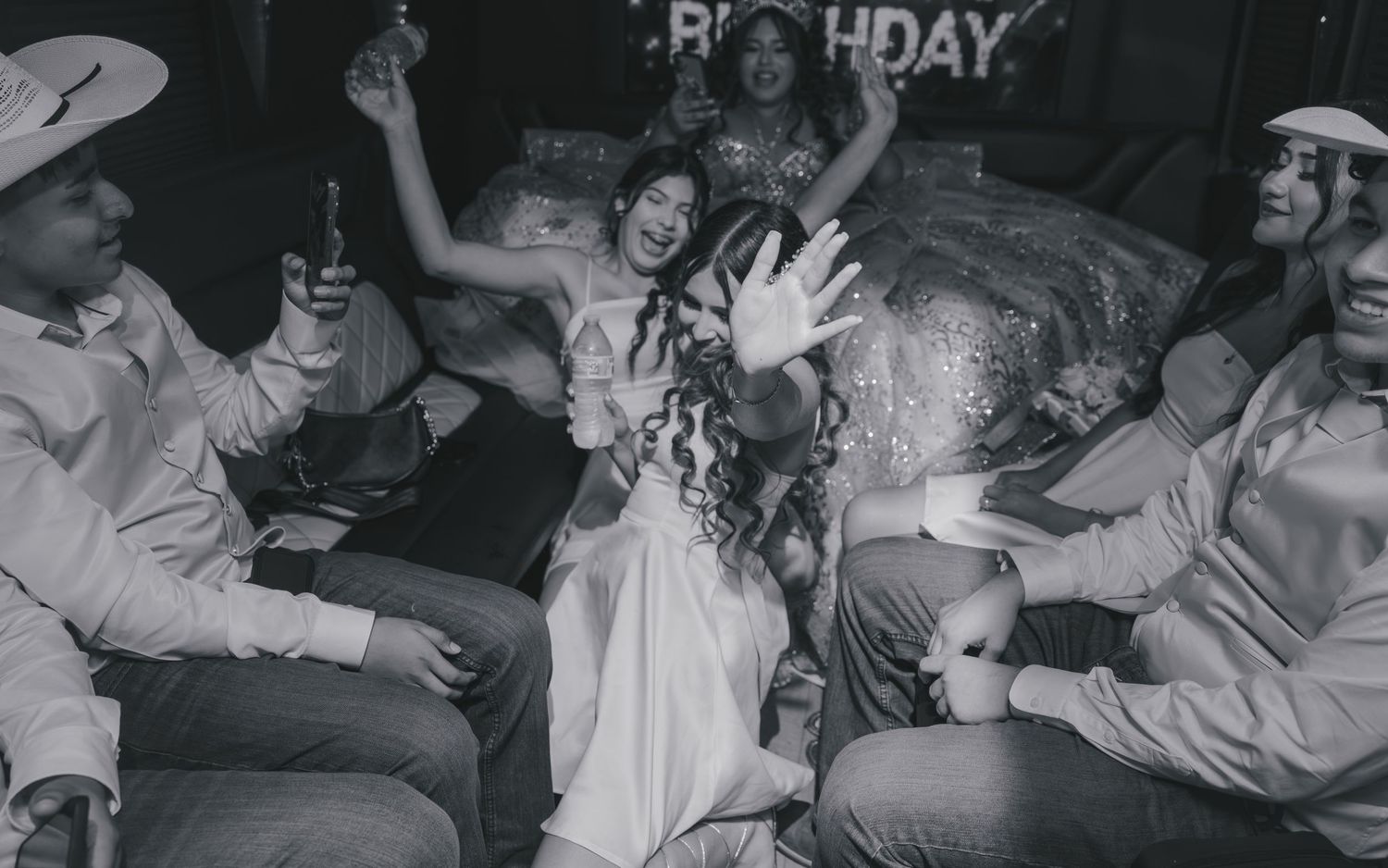 Black and white photo of a birthday party celebration with friends dancing and having fun indoors.