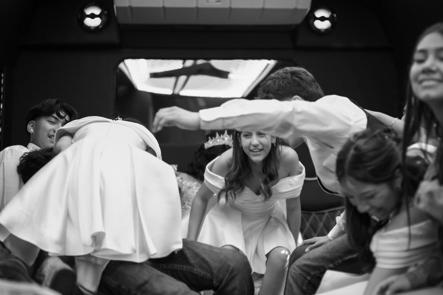 A group of people enjoying a dance party under bright lights in a black and white photograph.
