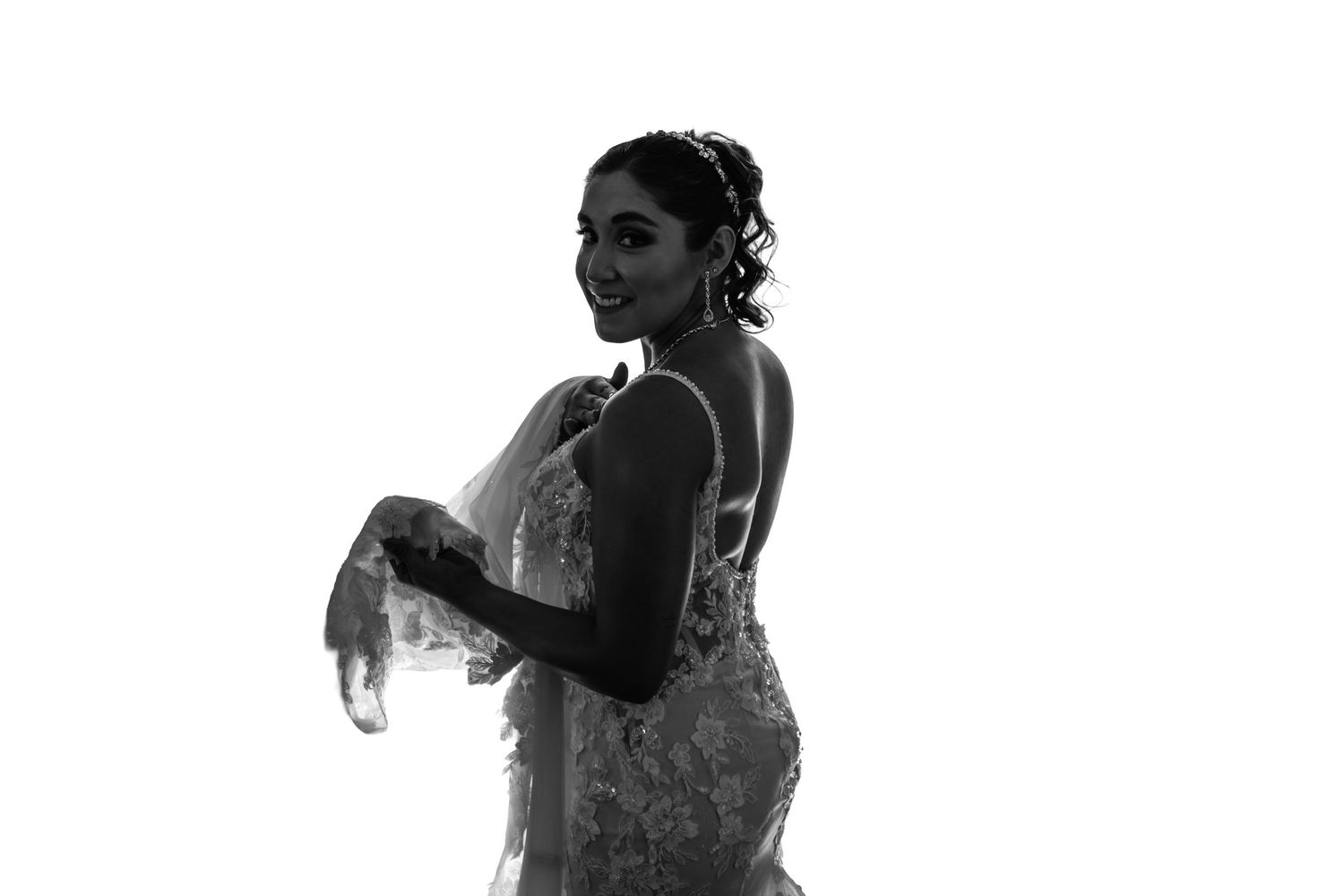 A silhouetted figure performs a graceful dance move against a bright background.