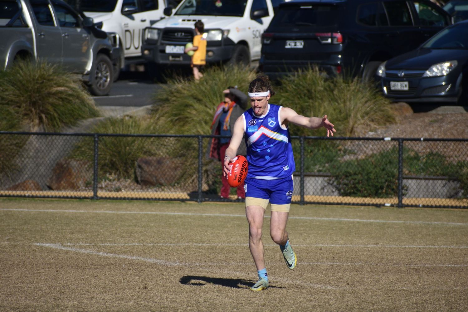 Running with the football about to kick the ball - sports photography