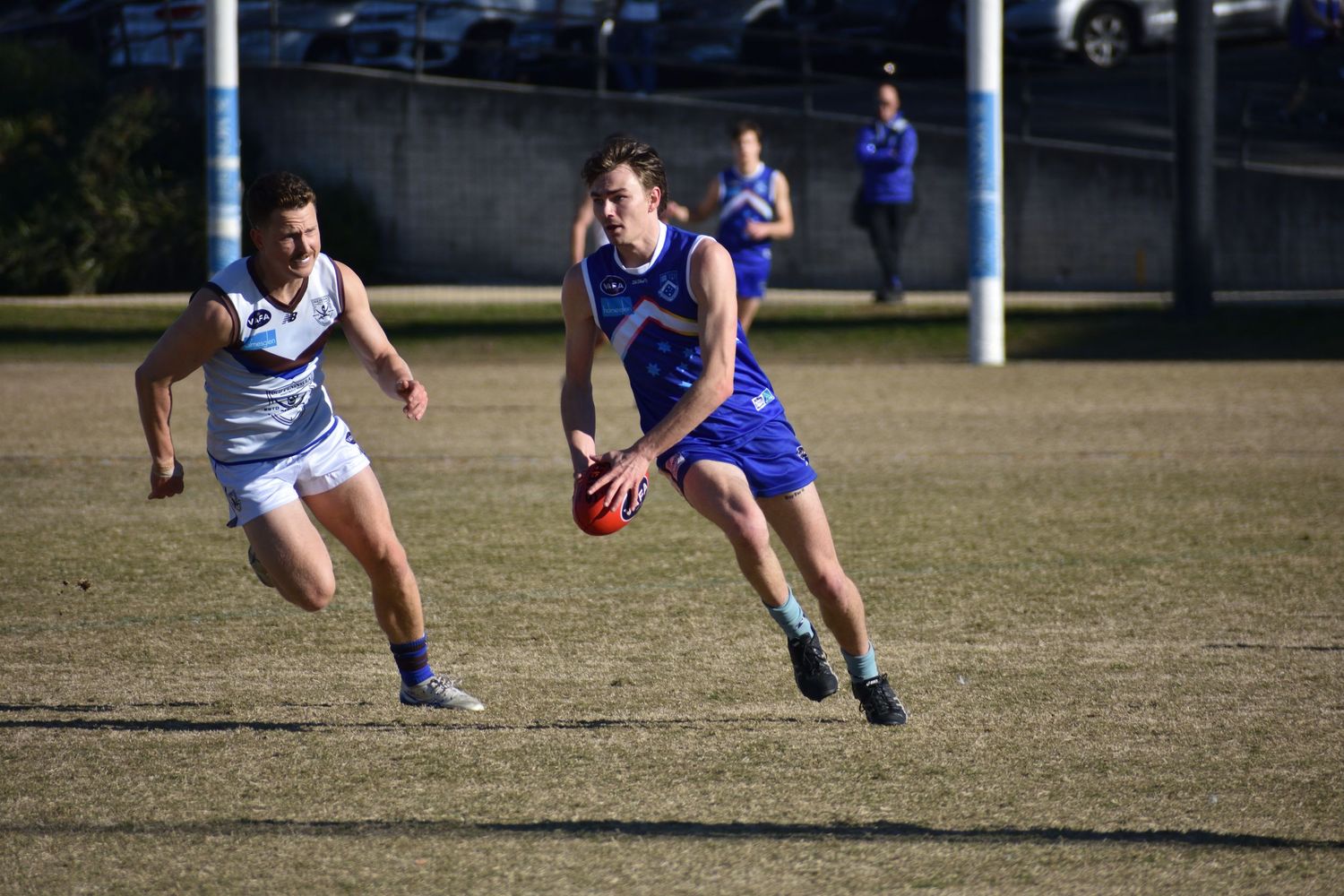 Running with the football about to kick the ball - sports photography