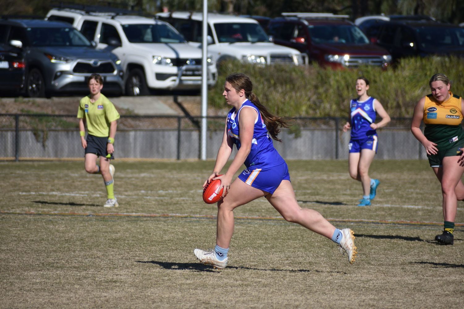Running with the football about to kick the ball - sports photography