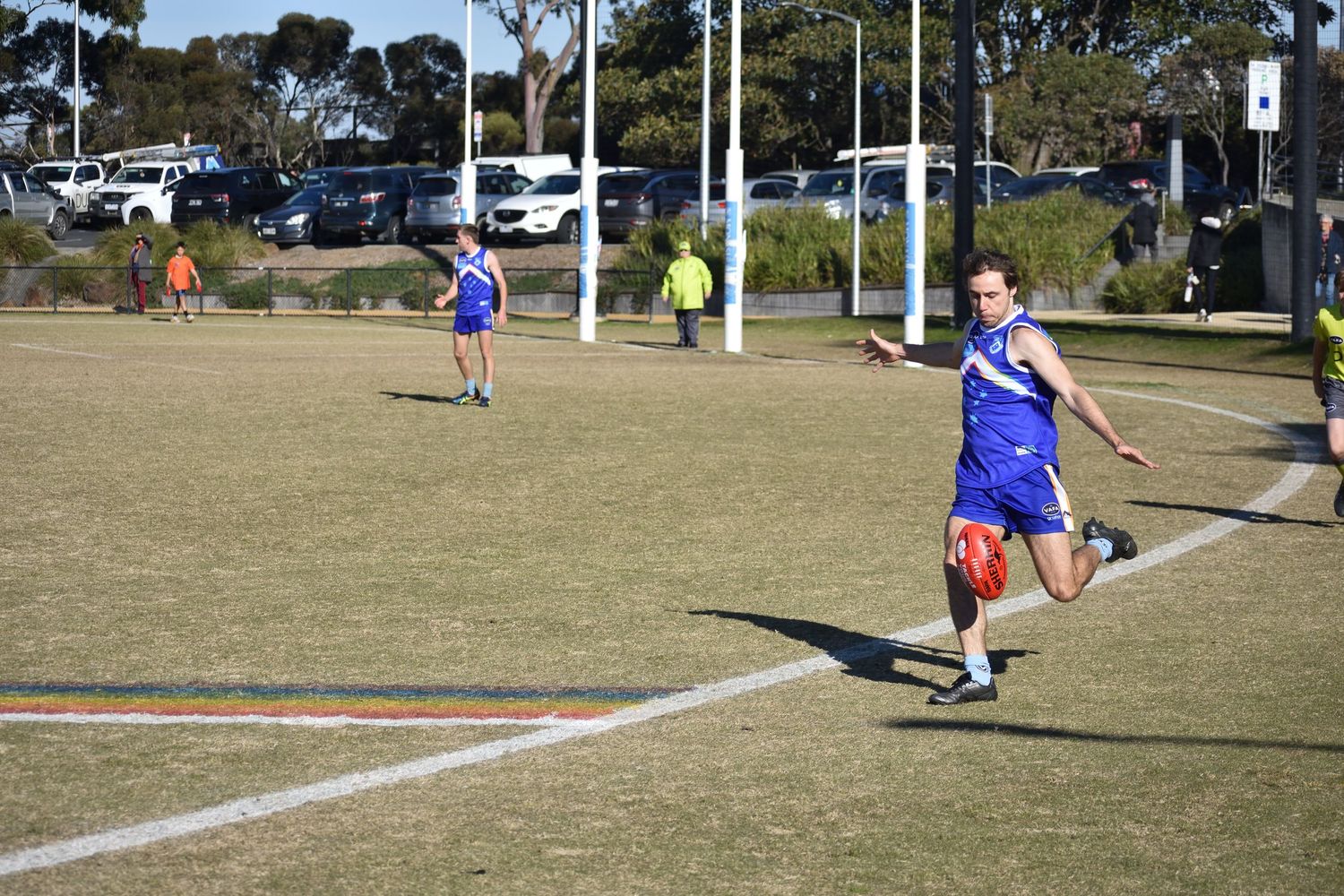 Running with the football about to kick the ball - sports photography