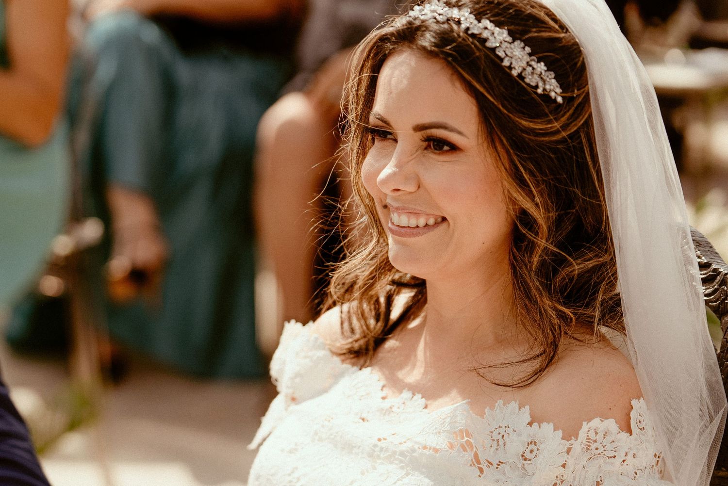 Four candid photos of a bride in a white wedding dress and veil smiling during her special day.