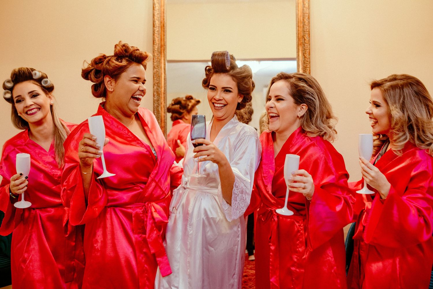 Wedding party in matching red robes poses together while getting ready for the ceremony.