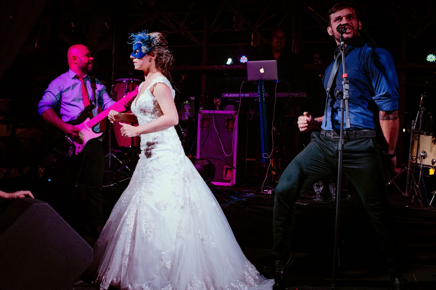 Couple dancing in formal attire under dramatic stage lighting at an evening reception.