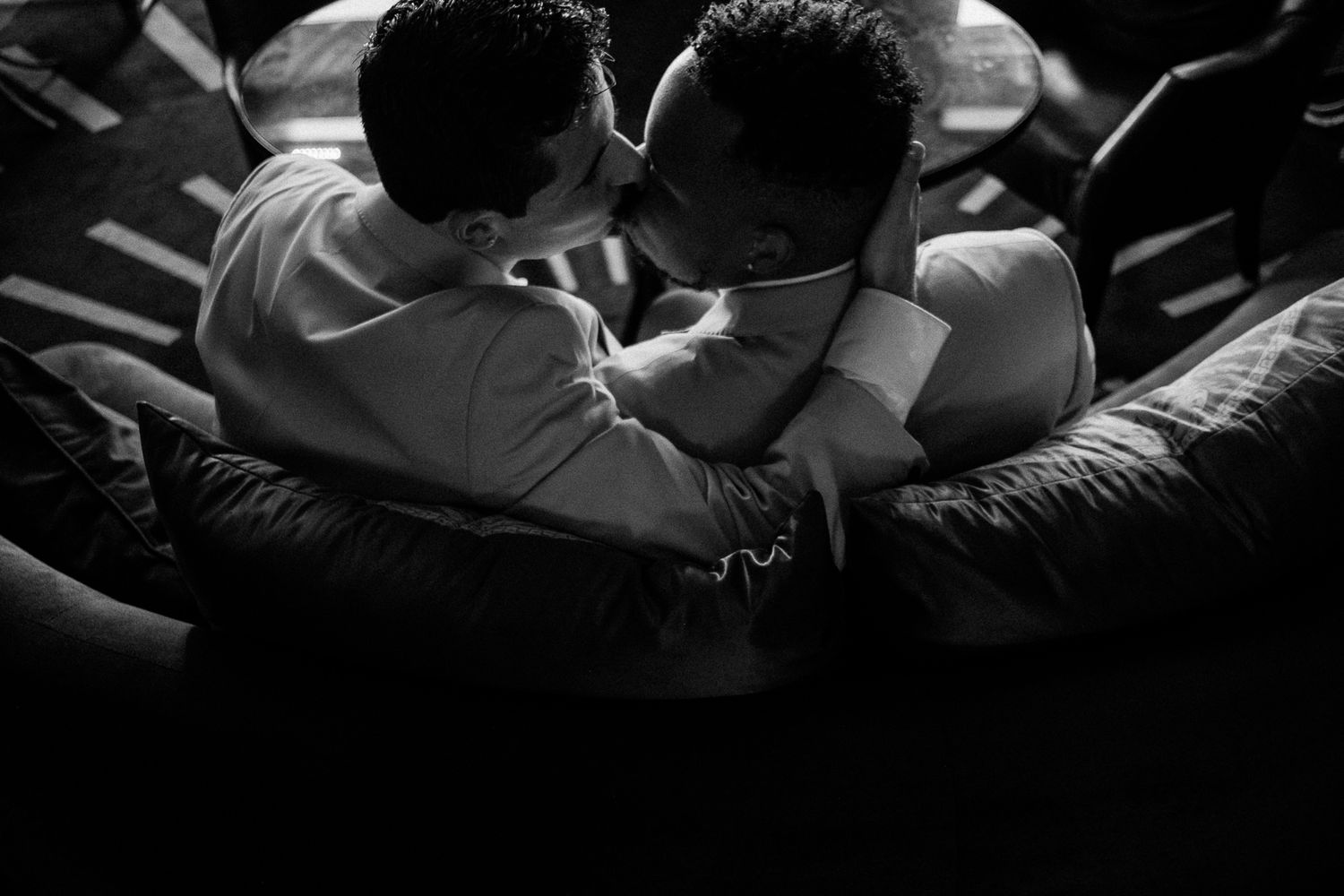 Black and white photo of two people sharing an emotional embrace, captured in dramatic lighting.