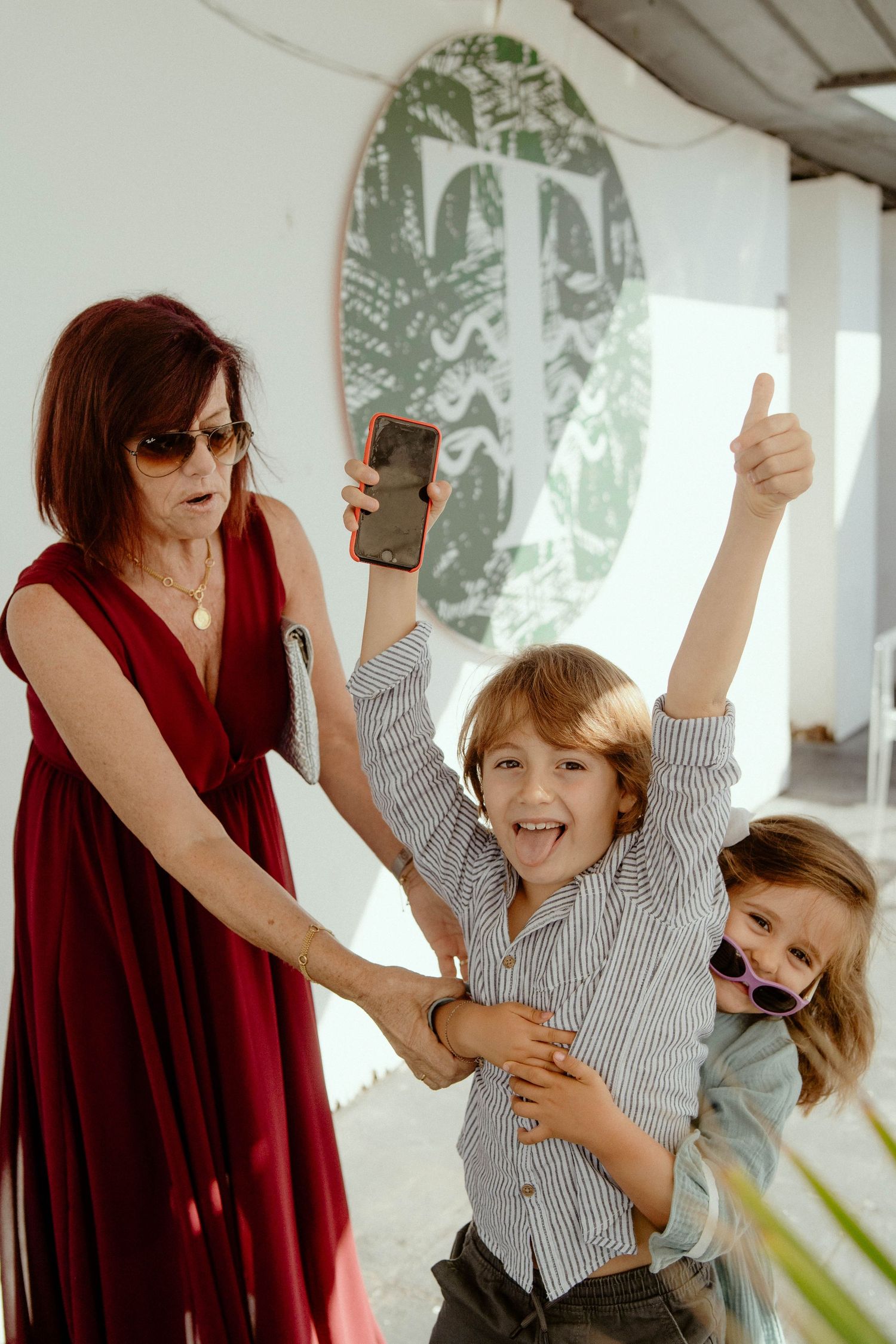 A sequence of four photos showing a child in a striped shirt dancing and moving playfully with an adult in red.