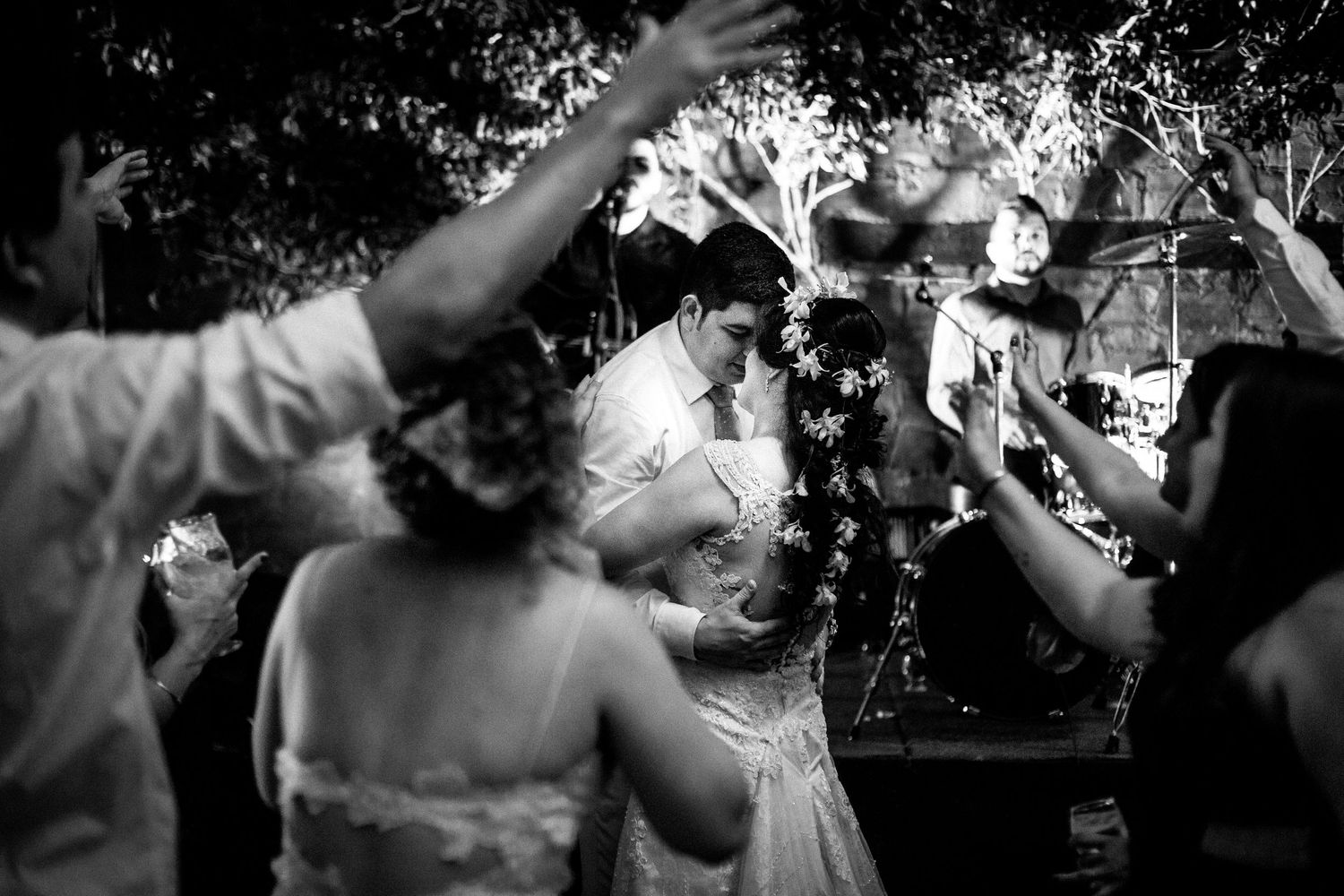 Black and white photo of wedding reception dancing with hands raised in celebration.