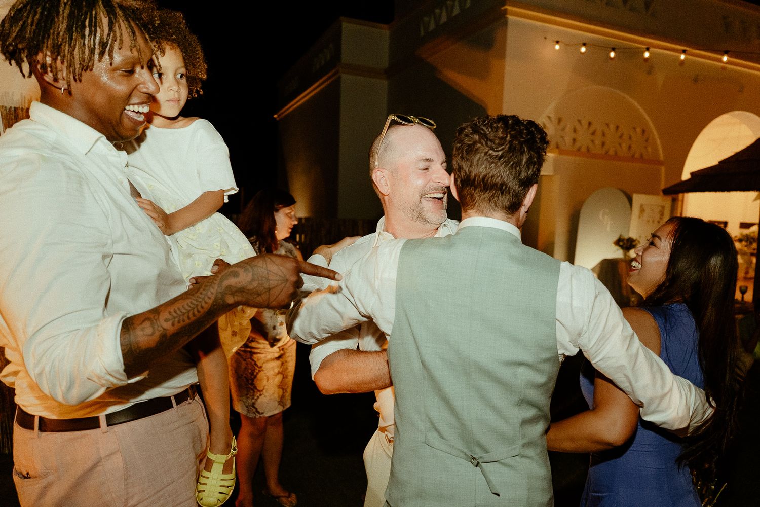 Guests celebrating and dancing together at a wedding reception in an elegant venue.