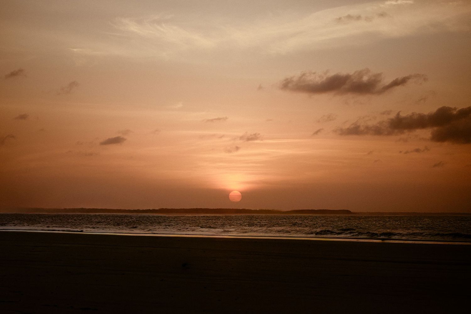 A series of peaceful ocean sunset photos with orange skies and breaking waves along the shoreline.