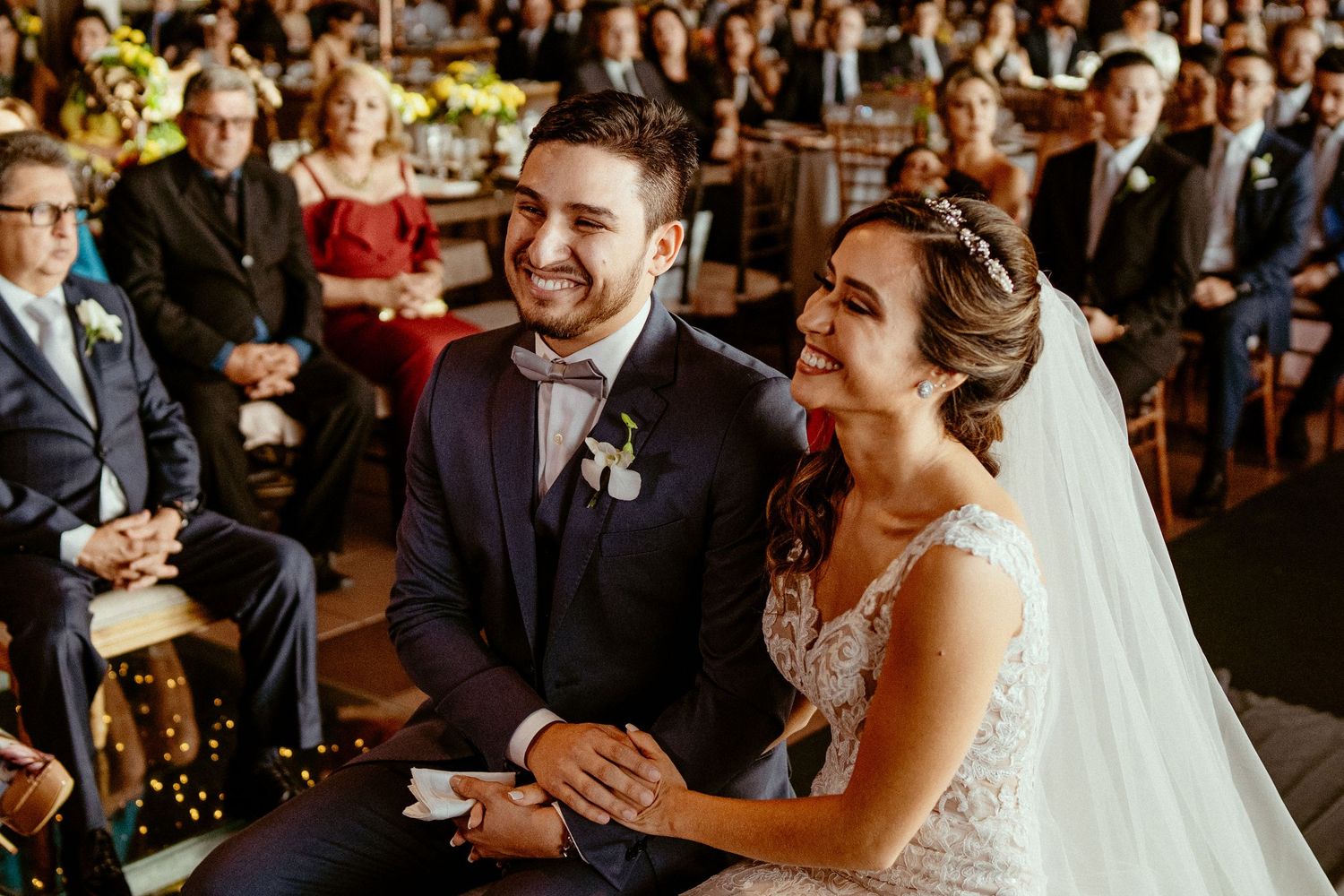 Wedding ceremony attendees sharing joyous laughter during the celebration.