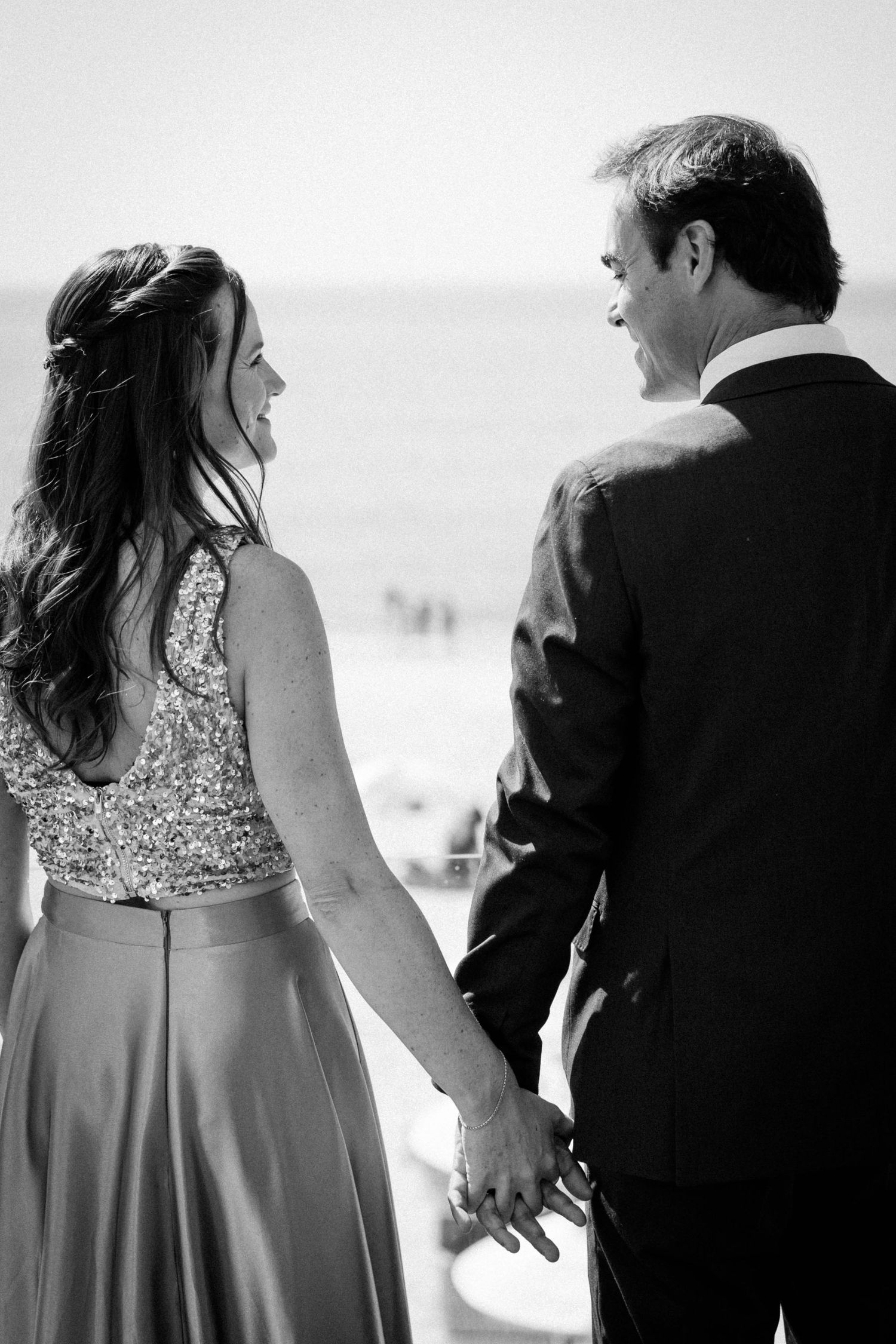 Black and white photo series showing a couple walking together, with focus on their silhouettes and formal attire.