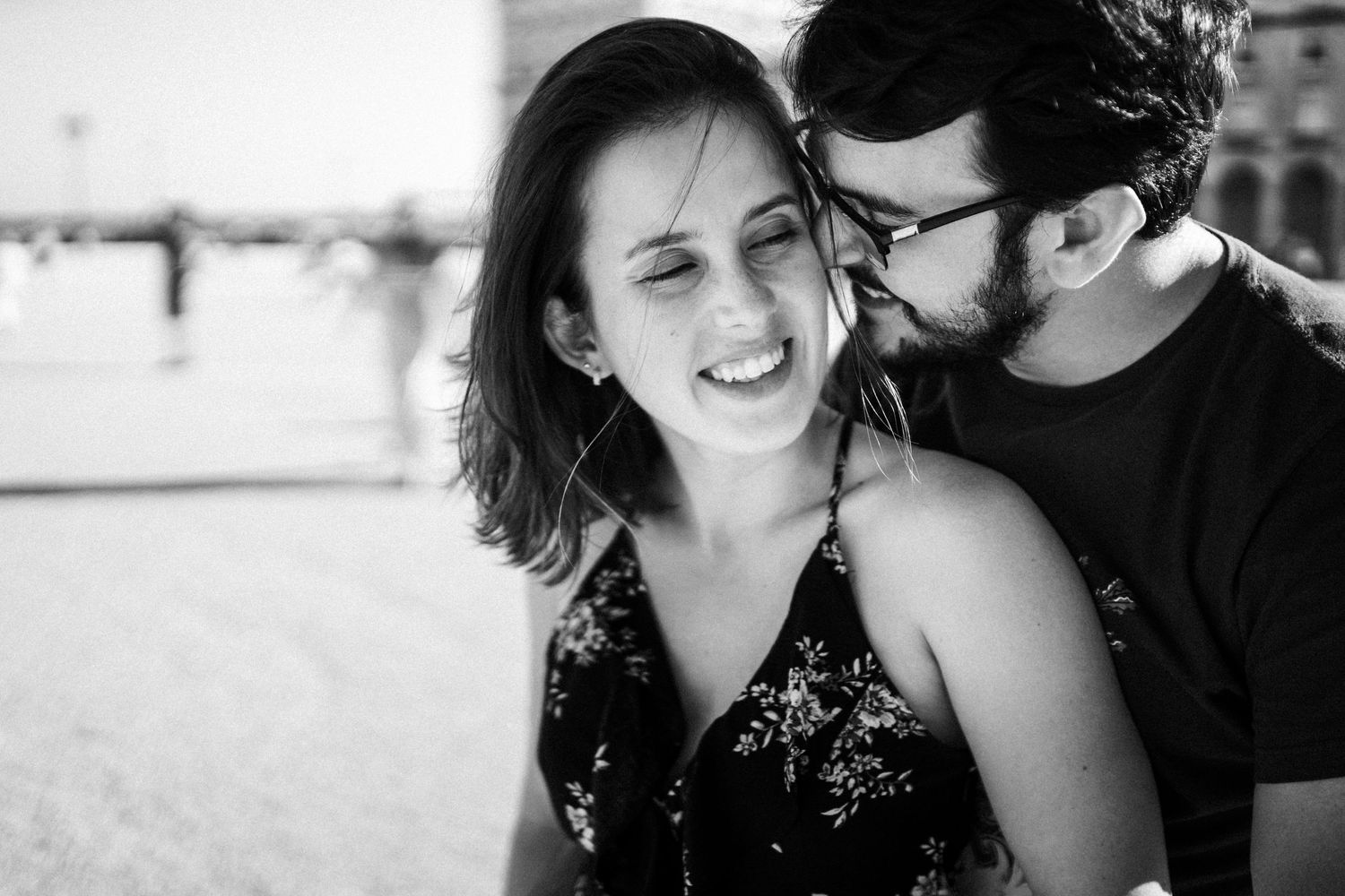 A black and white series of close-up photos showing a couple laughing and embracing together.