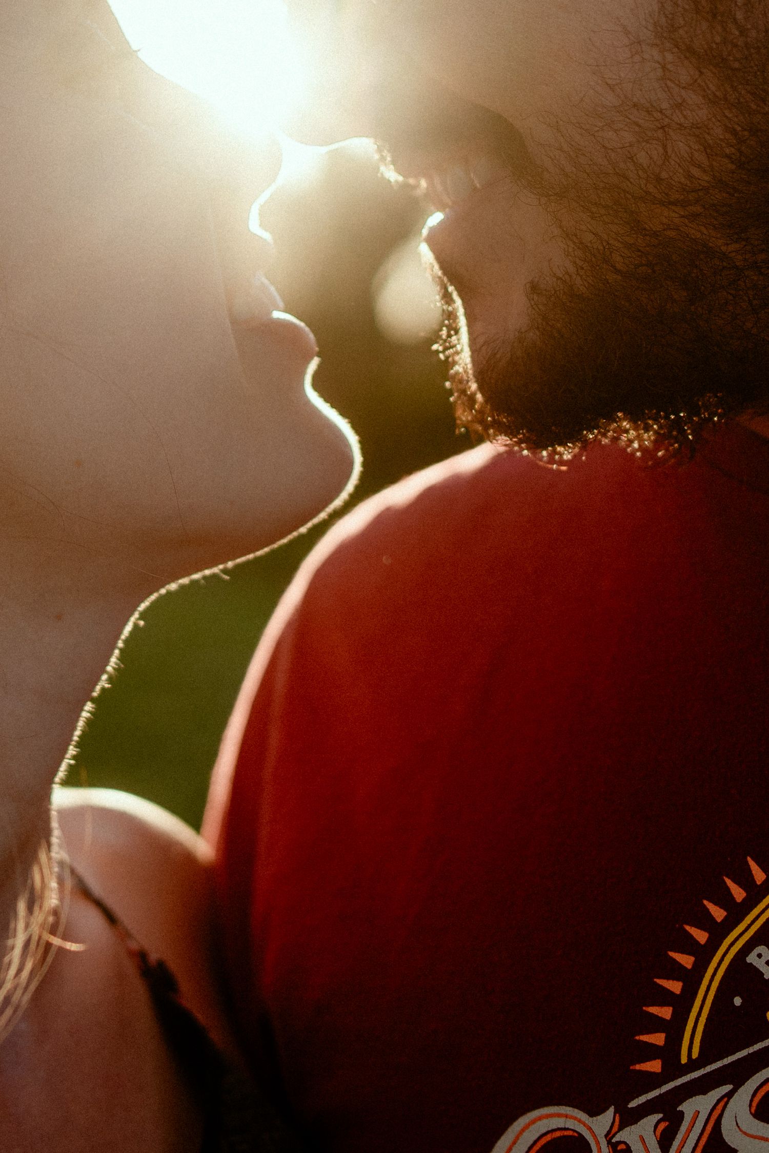 A silhouetted head in profile against a bright backlit glow creates a dramatic artistic contrast effect.