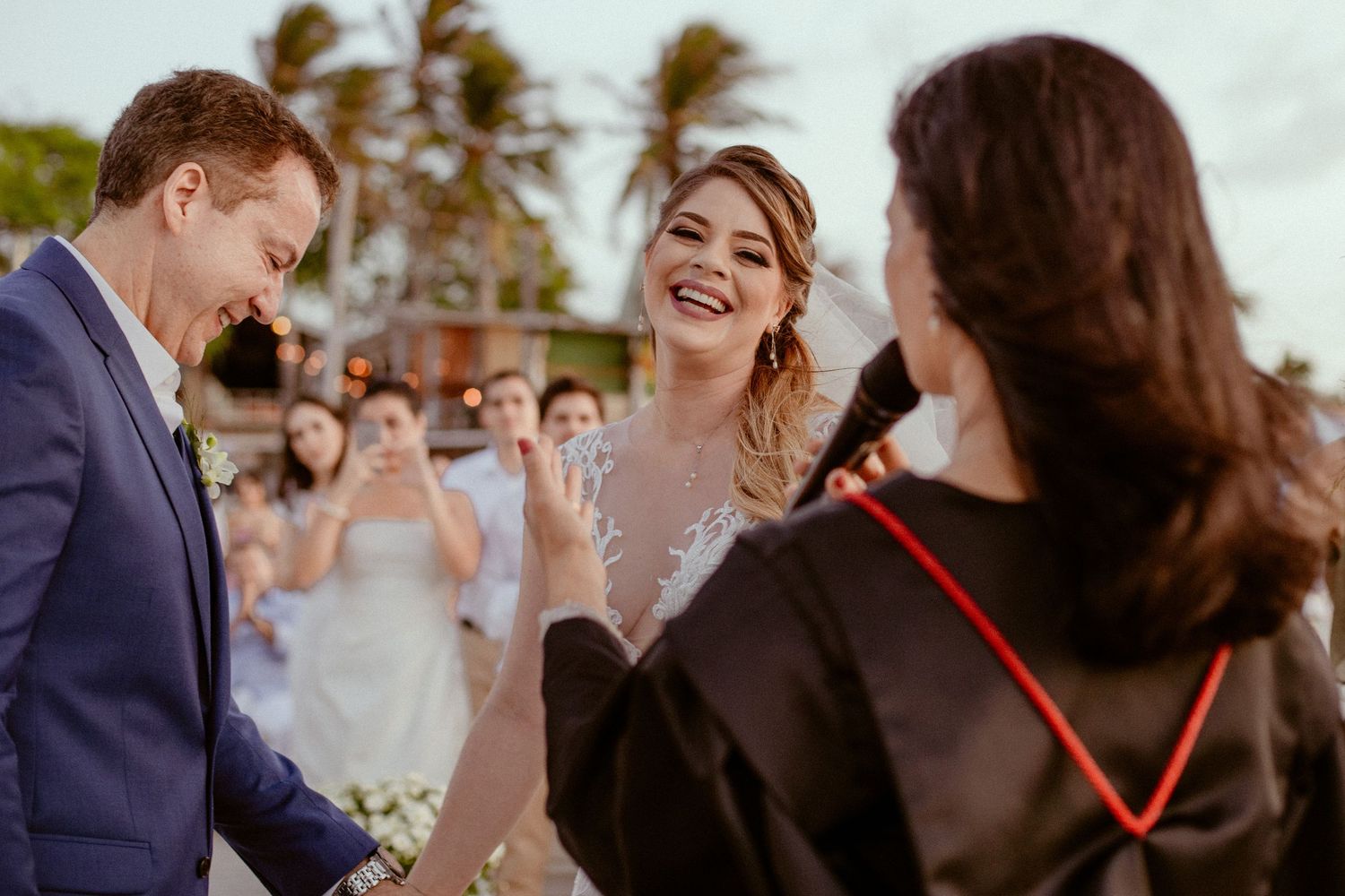 A happy couple shares their first dance at an outdoor wedding reception surrounded by joyful guests.