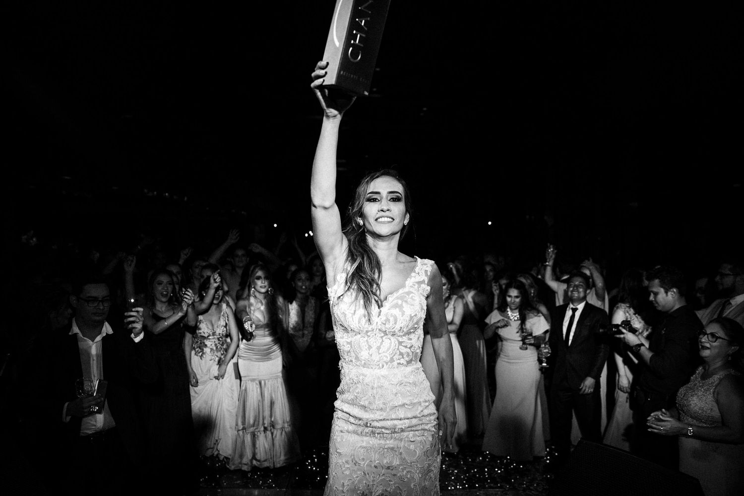 Black and white wedding photos show guests dancing and celebrating at a joyful reception.