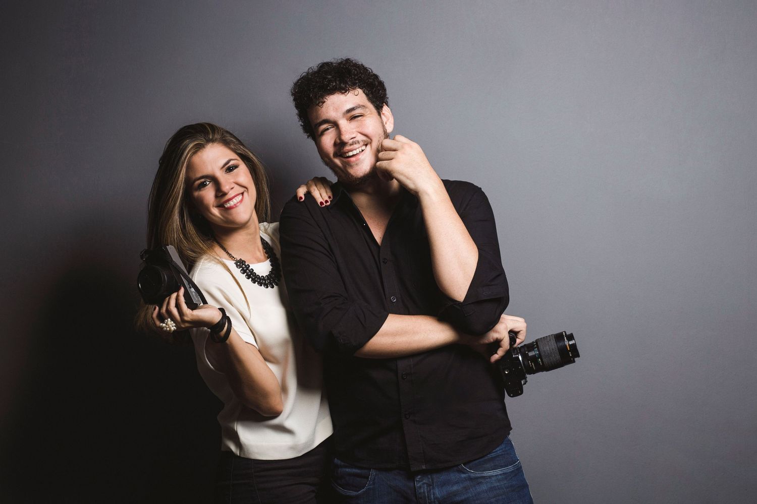 A romantic couple poses together in black and white studio photos showing affection and laughter.