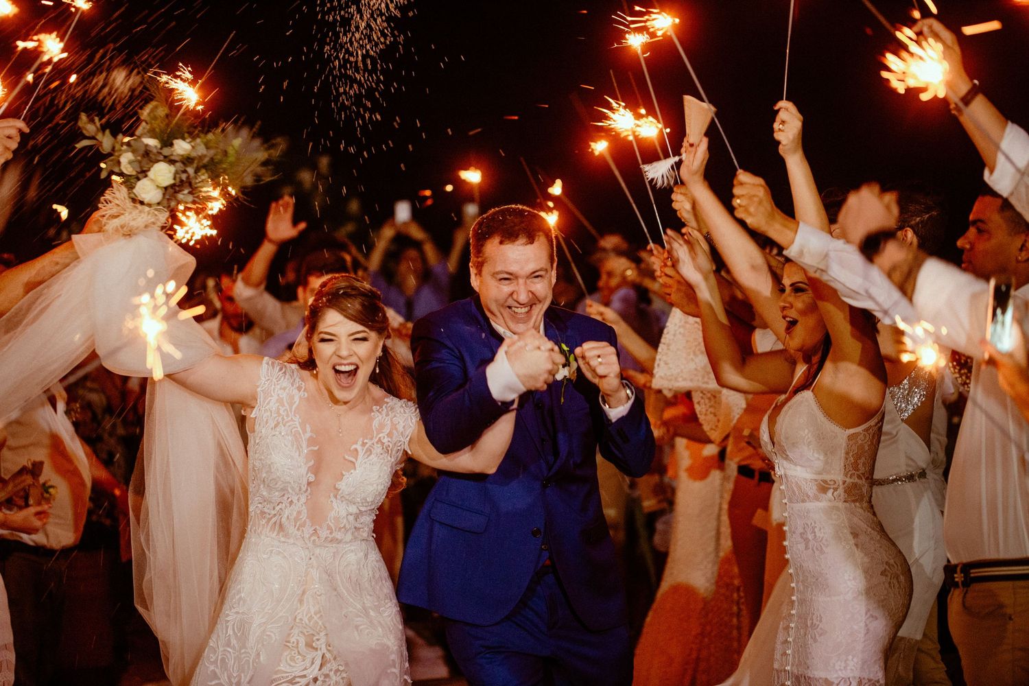 Wedding reception dance party with sparklers creating a magical nighttime atmosphere.