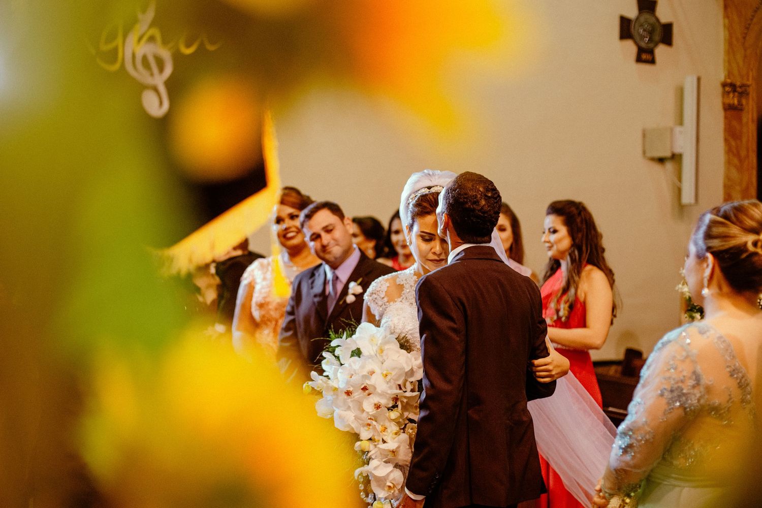 Wedding ceremony in progress with guests and wedding party in soft focus.