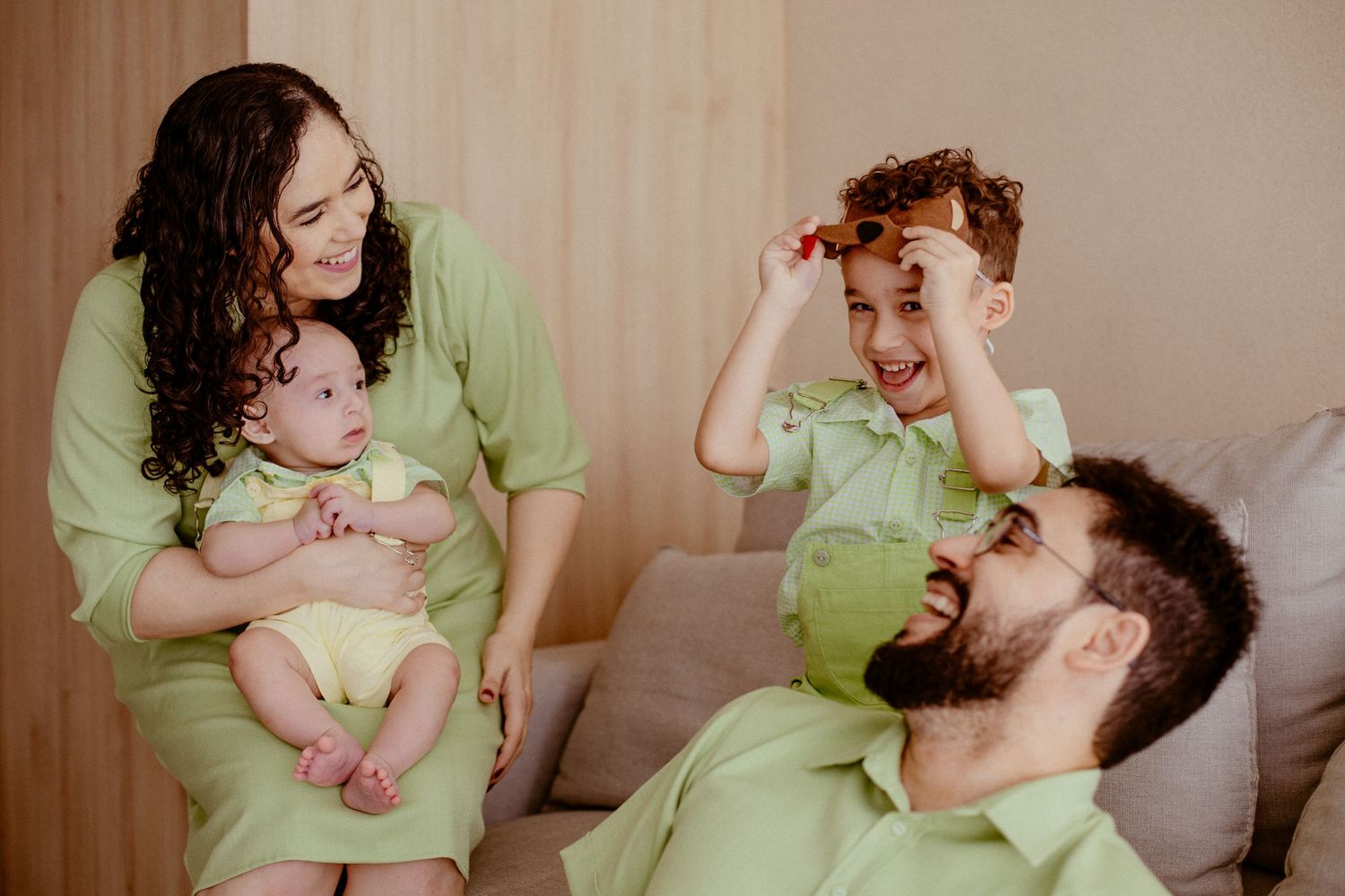 A series of six candid photos showing tender moments between a parent and baby wearing green clothing.