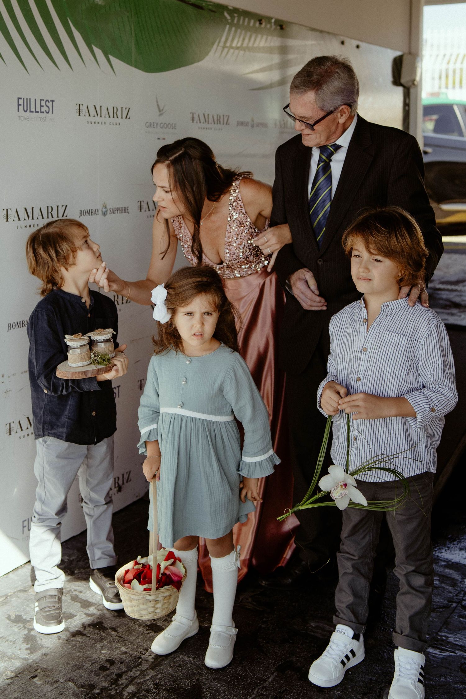 Elegant social gathering with guests mingling at an upscale event space decorated with palm leaves and branded backdrops.