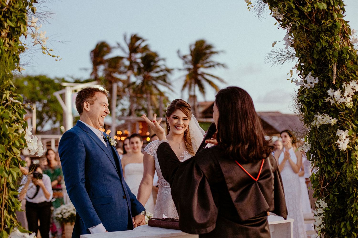 Tropical beach wedding ceremony with palm trees swaying in the breeze.
