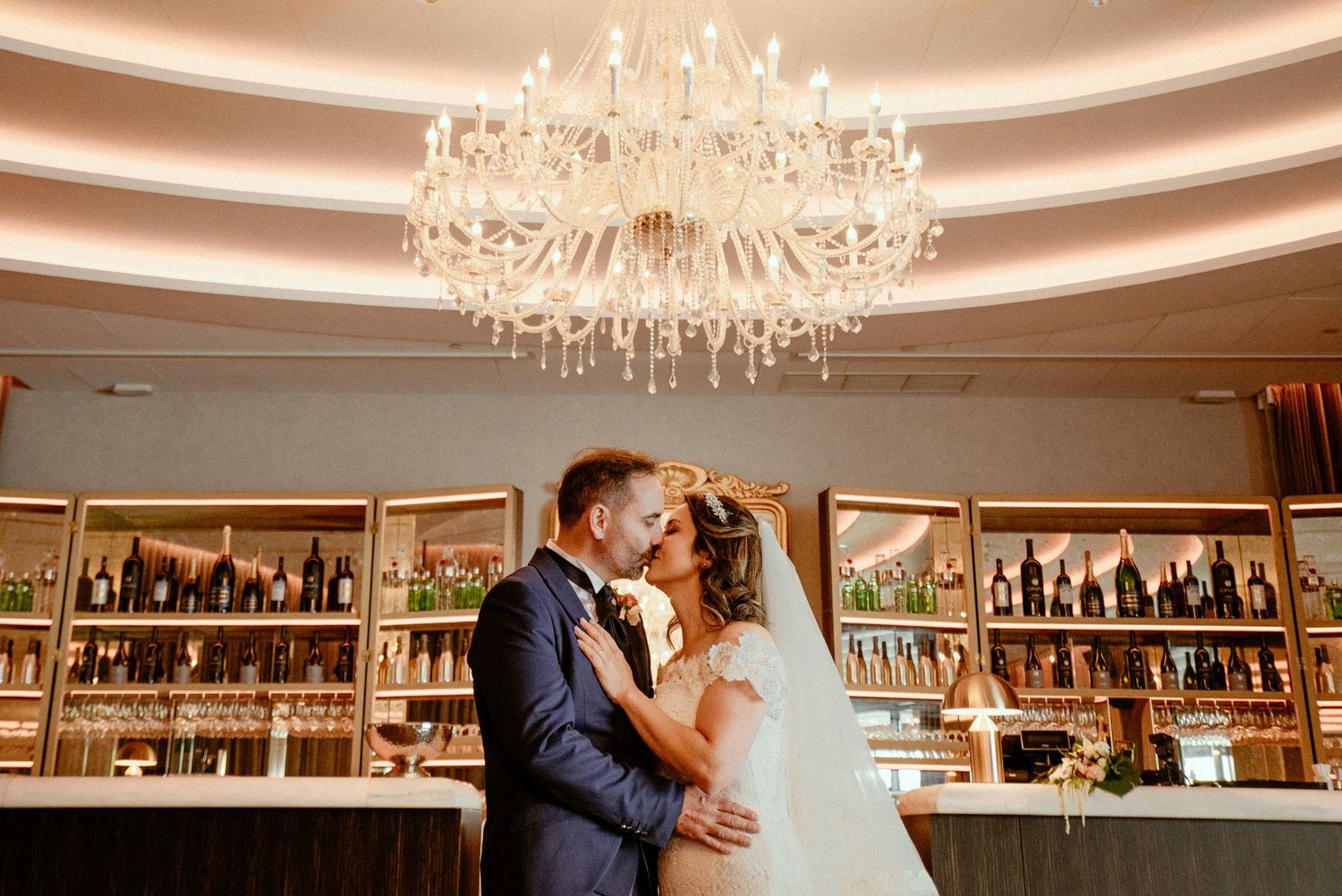A collection of photos showing elegant wedding moments in a beautiful venue with crystal chandeliers and ballroom decor.