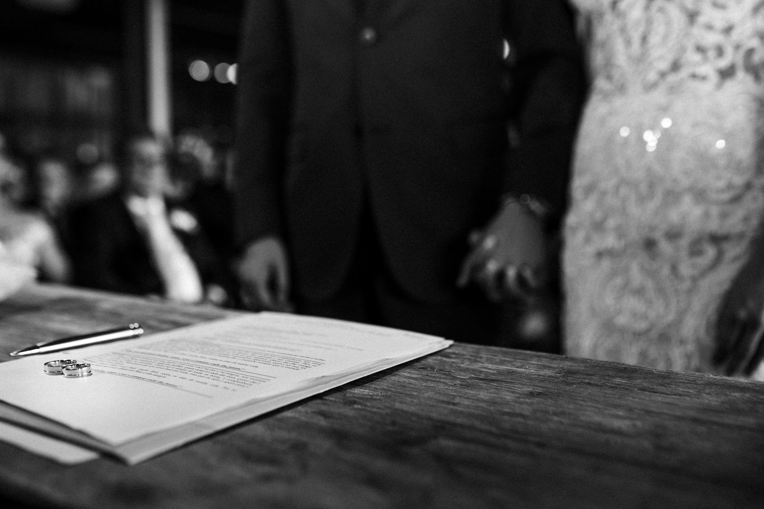 Close-up of signing a marriage certificate with a pen during a wedding ceremony.
