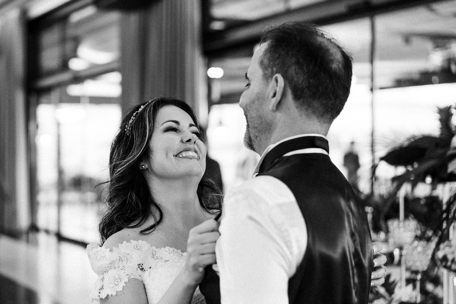 Tender candid black and white moments captured between smiling couples celebrating their wedding day.